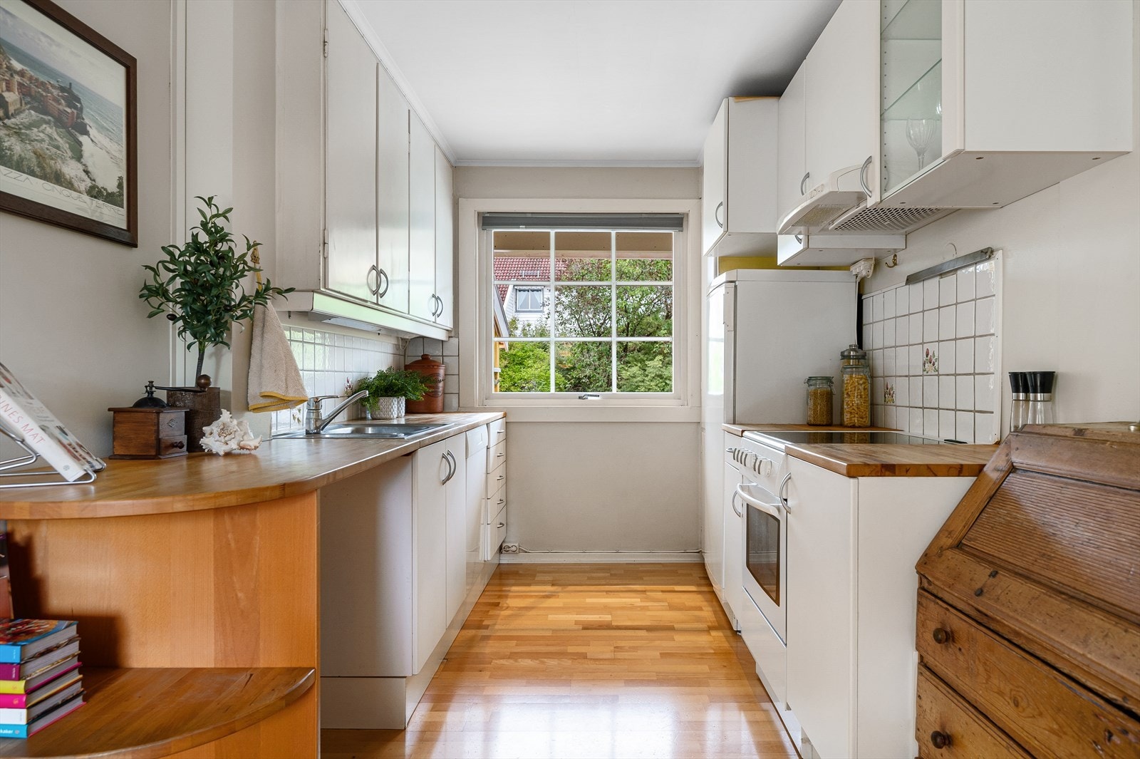 Kjøkken med glatte fronter, heltre benkeplate, ventilator og opplegg til oppvaskmaskin Galleribilde