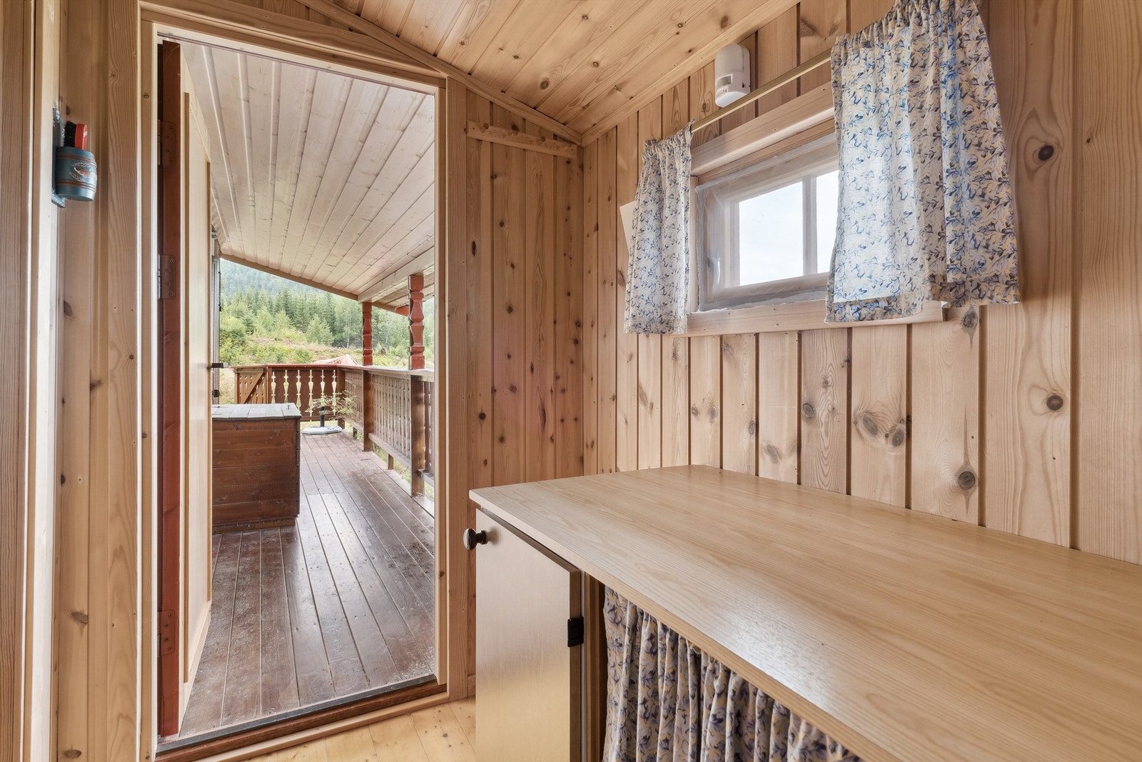 Her kommer man inn via et overbygget inngangsparti tilknyttet terrassen. Videre kommer man inn i en entré med panel på vegger og i himling og lakkert tregulv. Galleribilde