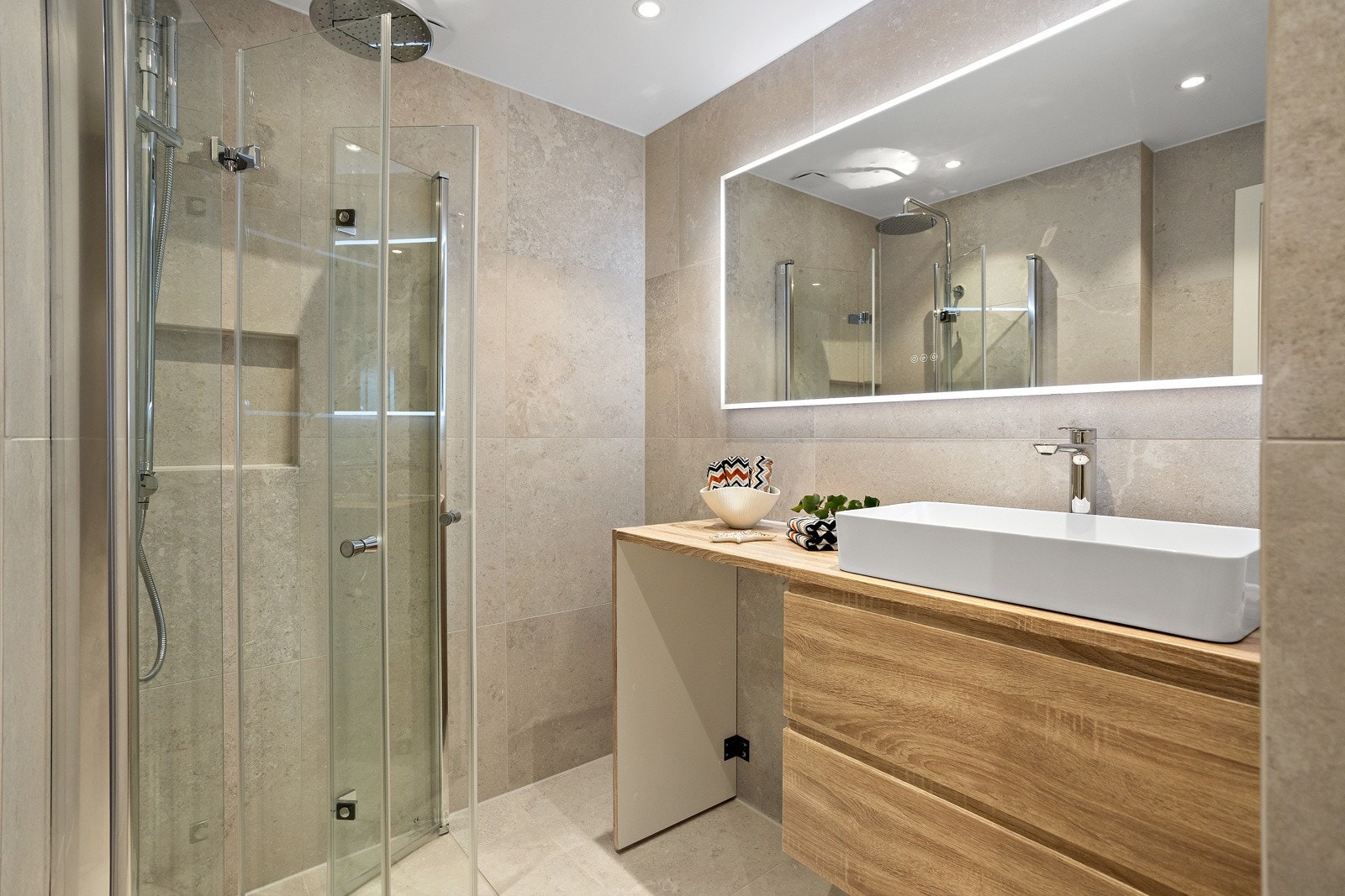 Lekkert utvidet baderom fra 2023. Innredning med skuffer og vask, videre har innredningen egen nisje til vaskemaskin Galleribilde