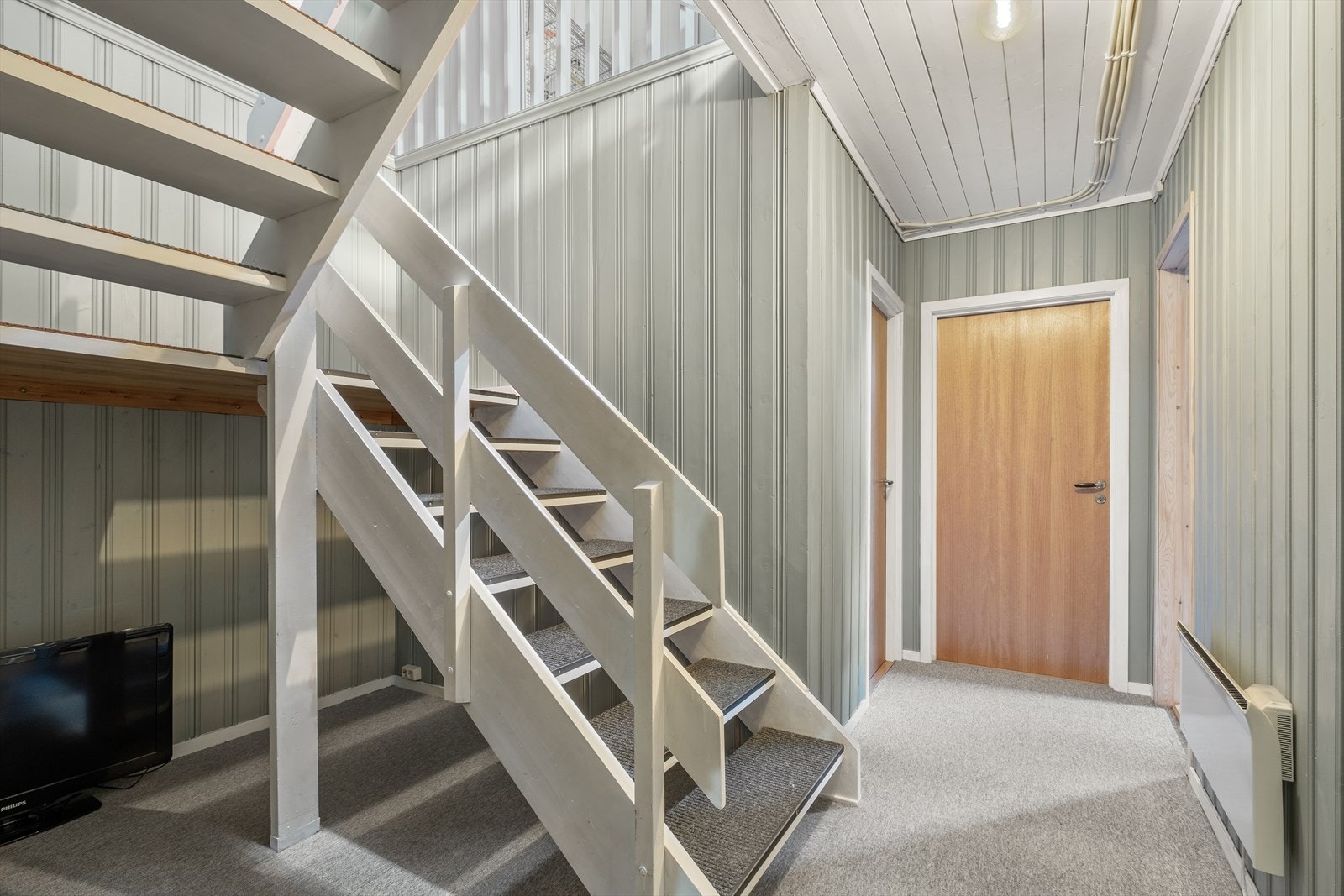 I kjeller er det teppegulv og det kommer mye naturlig lys fra 1. etasje. Døren rett frem fører ut Galleribilde