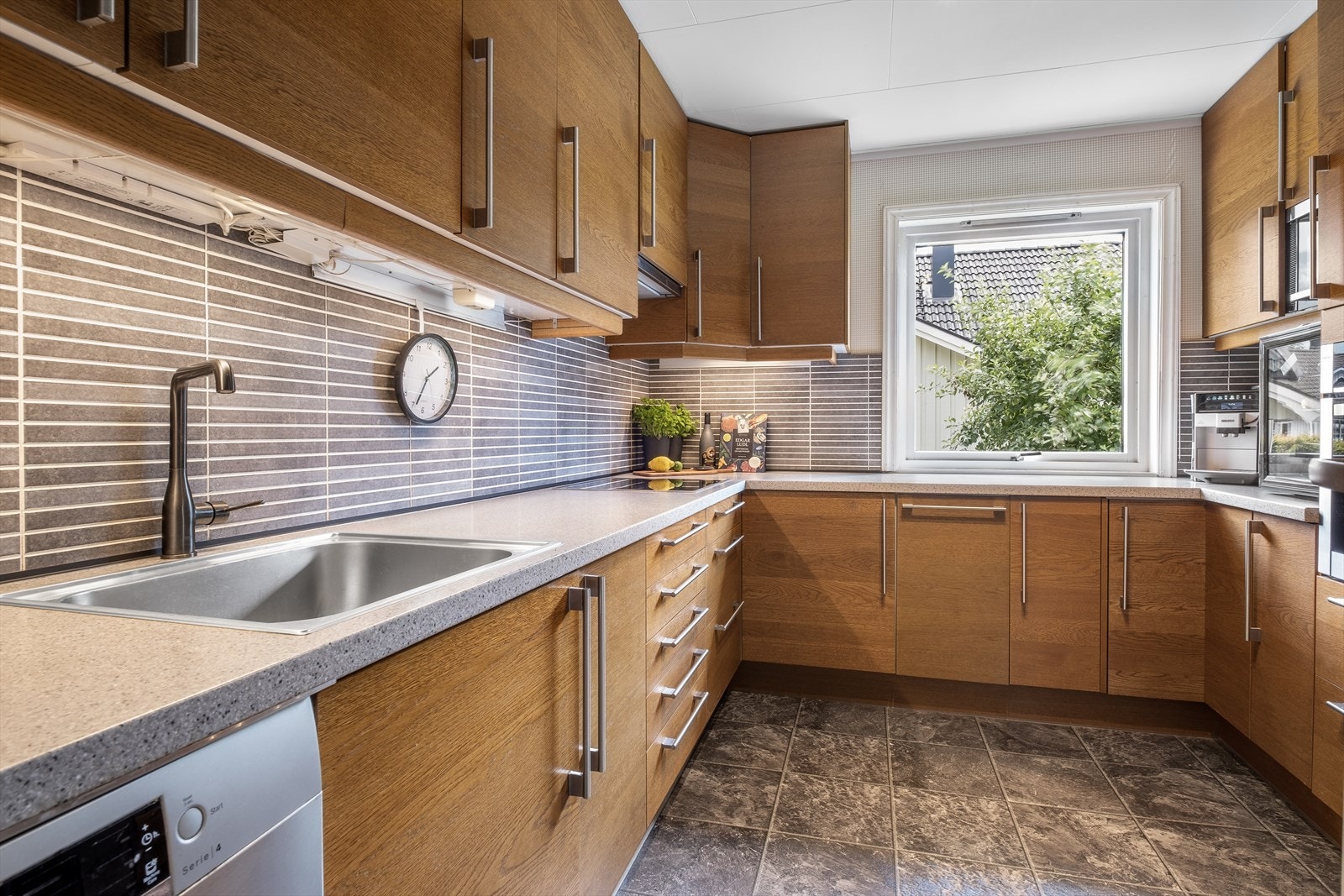 Romslig kjøkken med godt med benkeplass og skapplass og integrerte hvitevarer Galleribilde