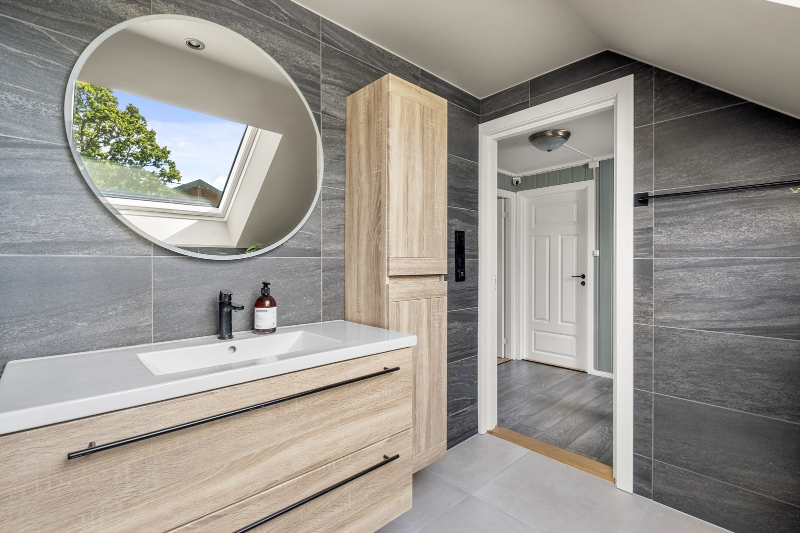 Det er skap ved siden av servant og det er lys i speilet Galleribilde