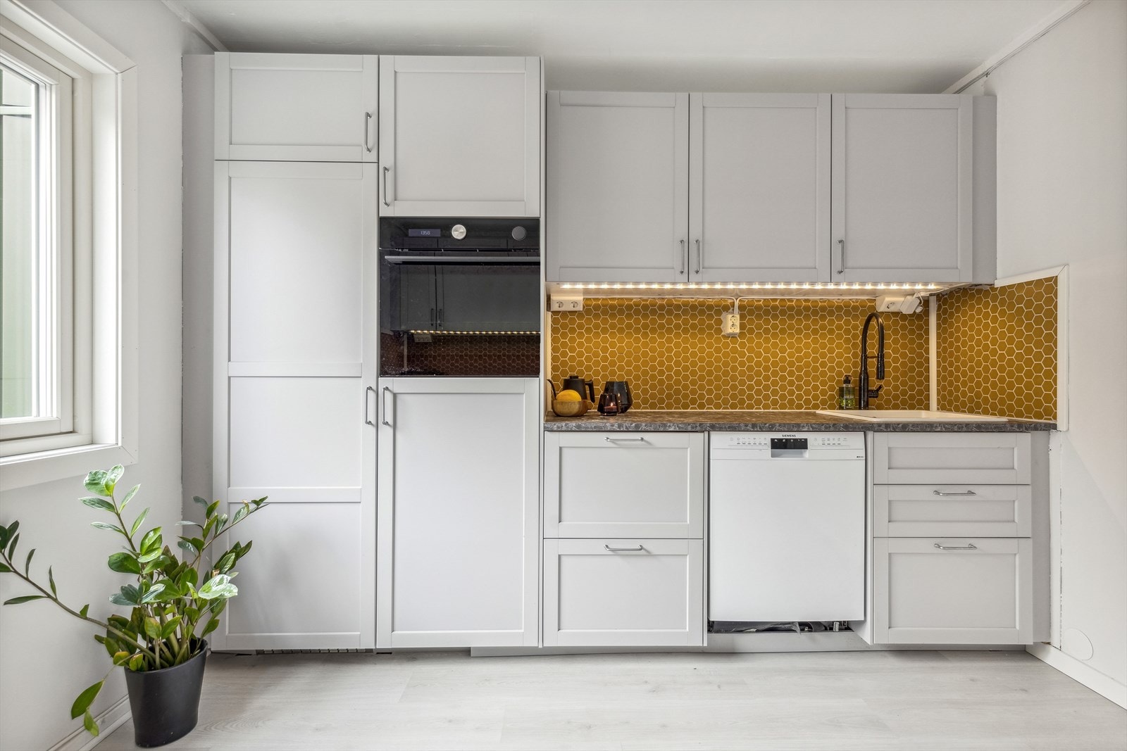 Kjøkkeninnredning er ny i 2022 med grålakkerte profilerte fronter og laminert benkelate. Galleribilde