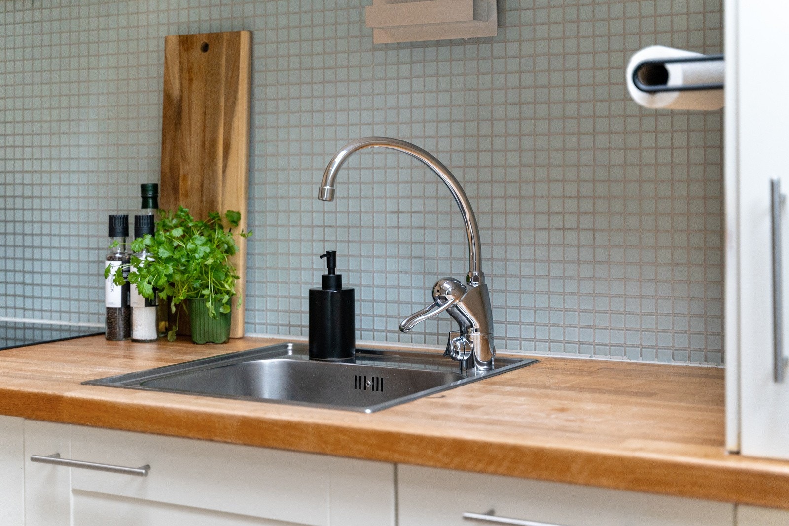 Kjøkkeninnredningen har profilierte fronter, benkeplate av tre og fliser mellom kjøkkenbenk og overskap. Galleribilde