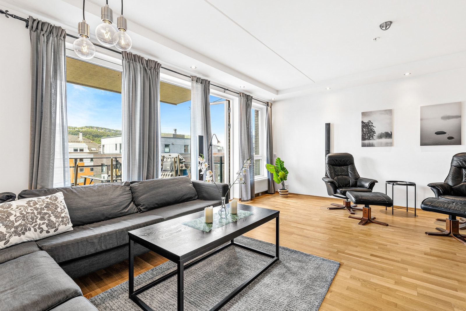 Veltalende stue med store vinduer i sammenheng med et koselig og solrikt uterom. Galleribilde