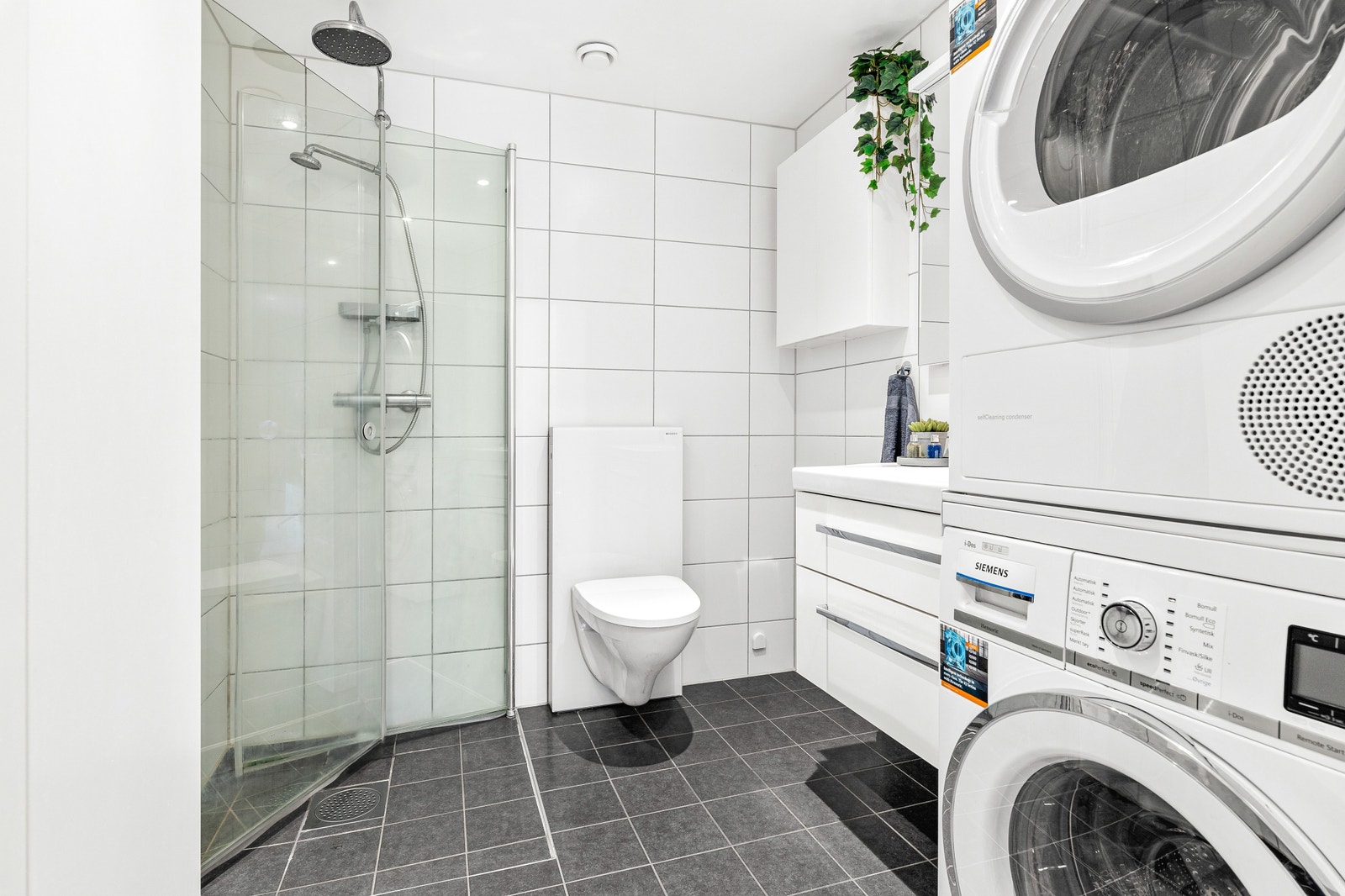 Moderne elegant flislagt bad. Med Integrerte takspotter. Vegg og 2 Høyeskap. Plass til vaskemaskin og tørketrommel. Galleribilde