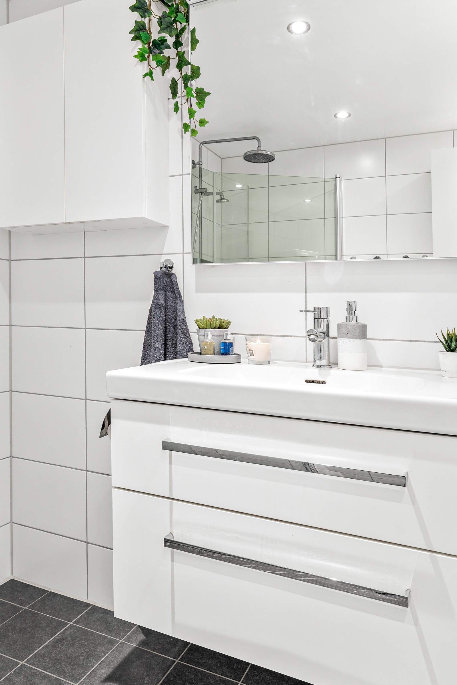 Pen og moderne inn-redning med speil og belysning over servant. Galleribilde