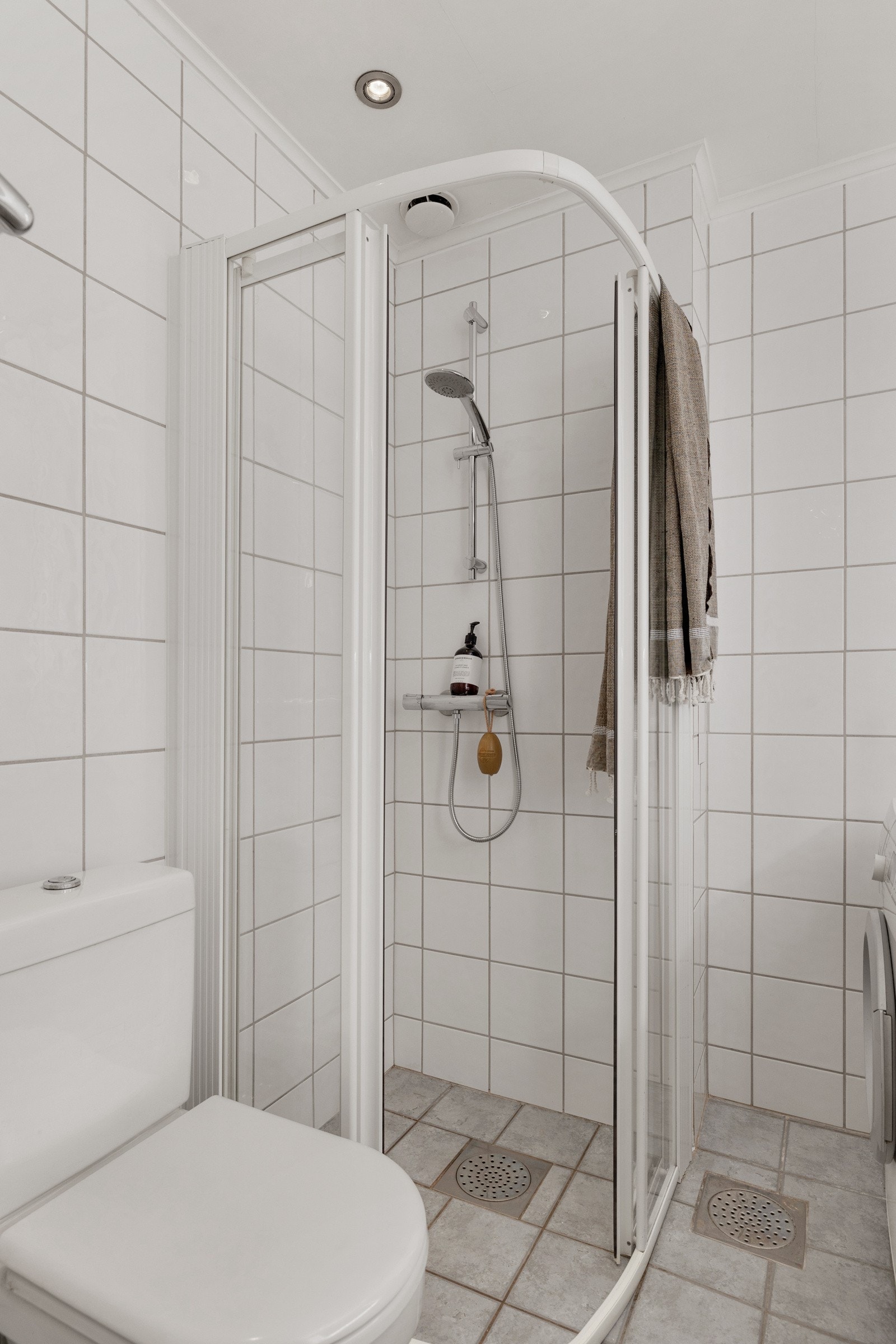 Badet inneholder servantinnredning med skuffer og servant i porselen med ett-greps armatur og veggmontert speil med lys. Servantinnredning og speil nytt i desember 2023. Galleribilde