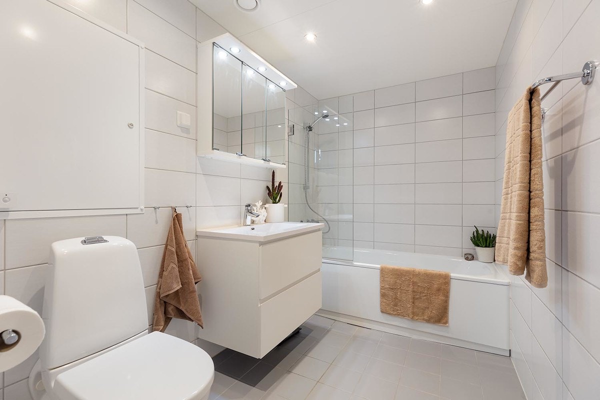 Baderom tilknyttet hovedsoverommet. Badet har flislagte overflater, et oppvarmet gulv og badekar. Galleribilde