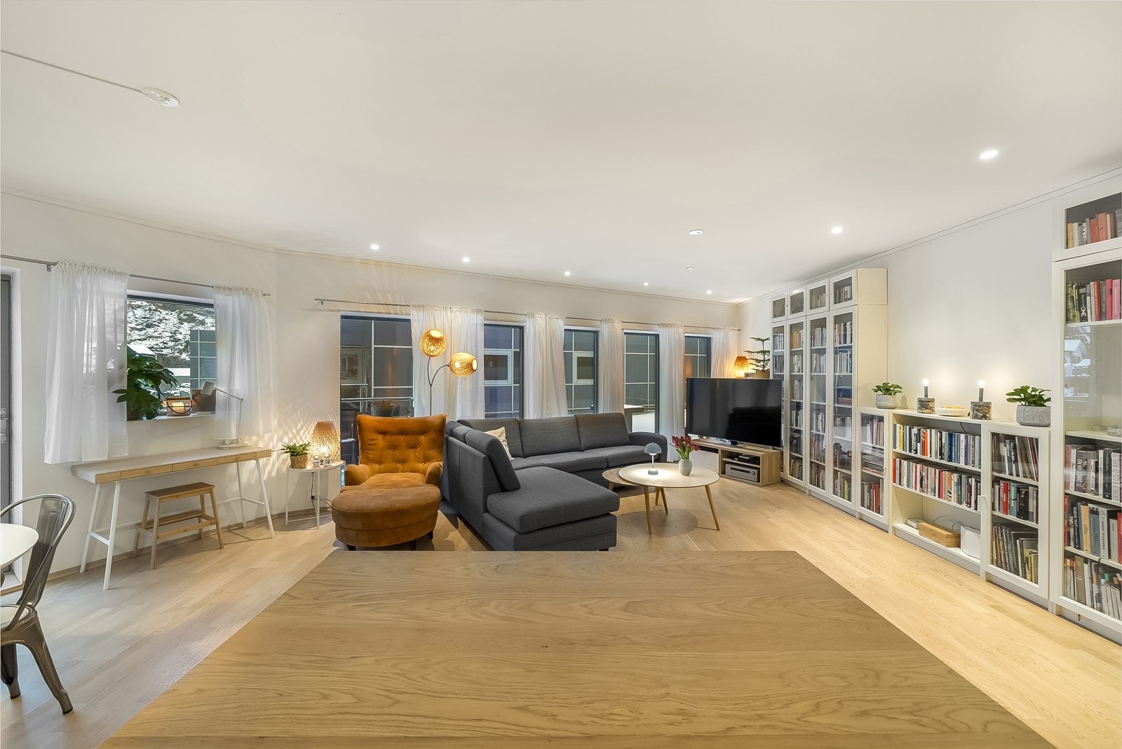 Lys stue med generøse vindusflater og downlights i tak. Galleribilde
