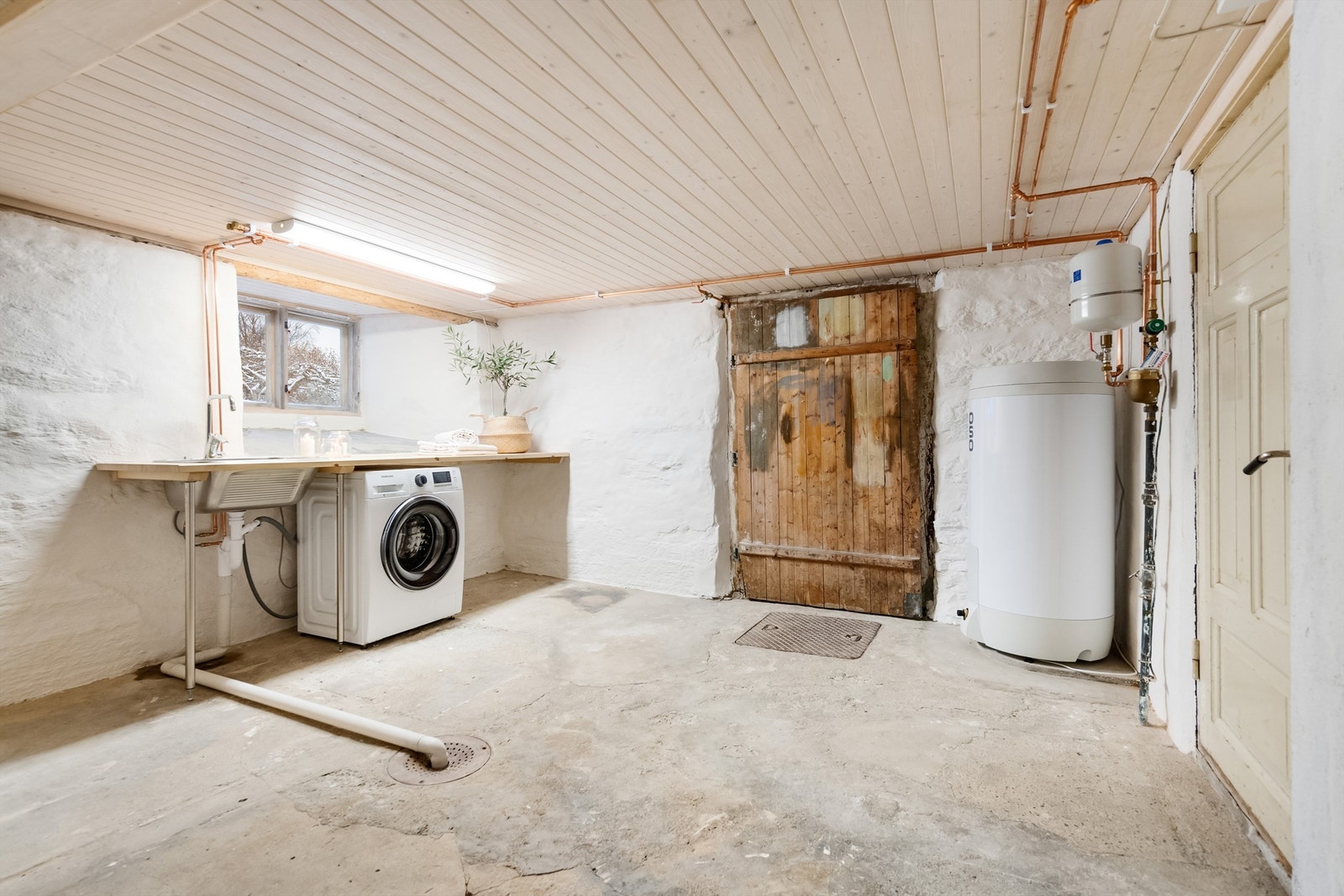 Disponibelt rom i kjeller innredet med opplegg for vaskemaskin. Galleribilde