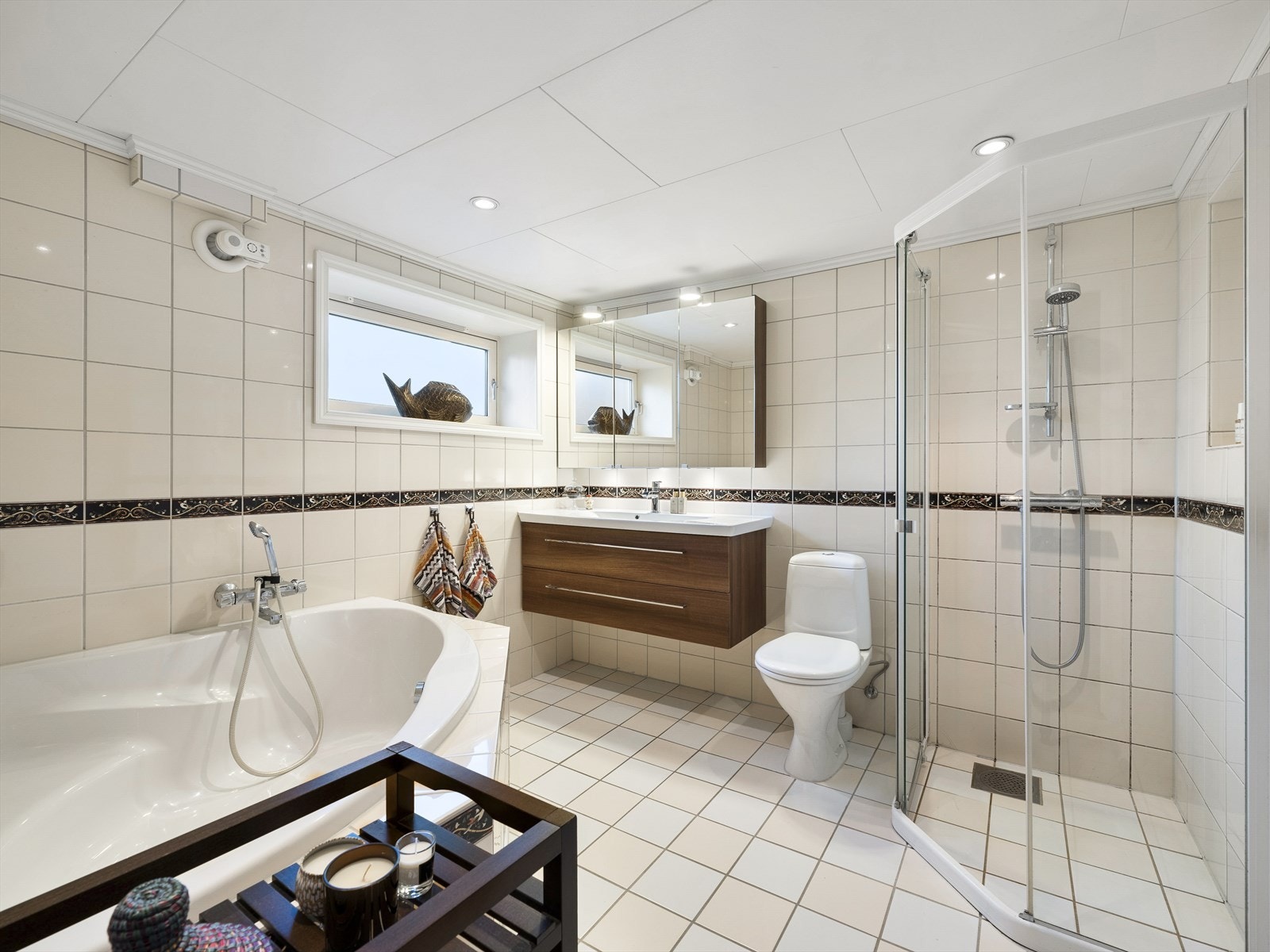 Pent helfliset bad med hjørnebad, dusjhjørne, toalett og moderne innredning. Galleribilde