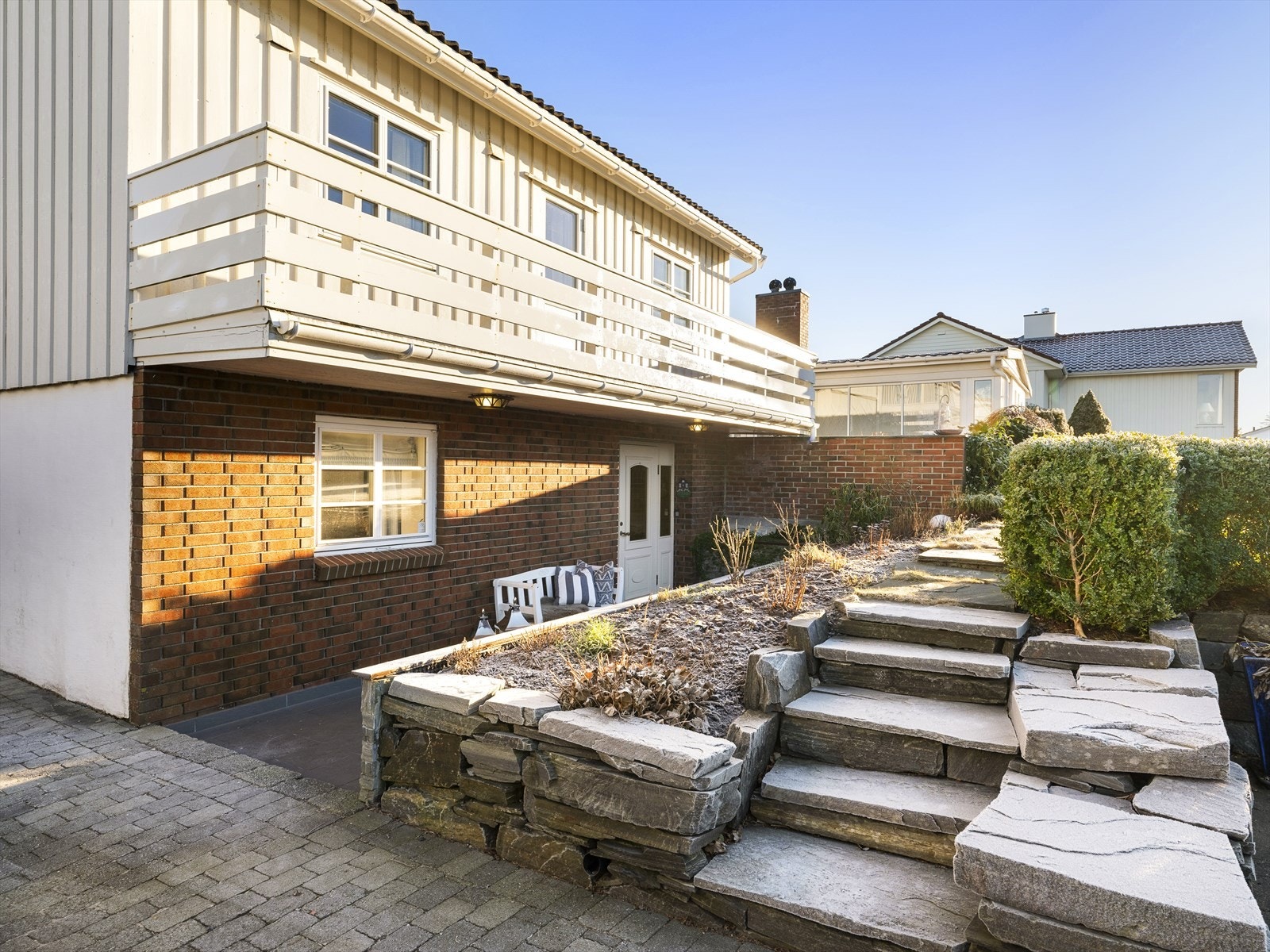 Fint opparbeidet inngangsparti med bi-inngang til underetasjen. Parkering i steinbelagt gårdsrom og i carport. Galleribilde