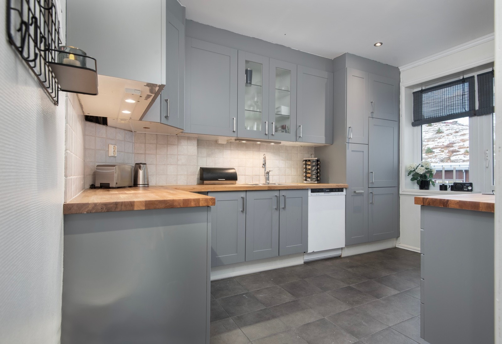 Kjøkkeninnredning fra Ikea med integrert stekeovn, platetopp og kjøle-/fryseskap. Frittstående oppvaskmaskin. Galleribilde