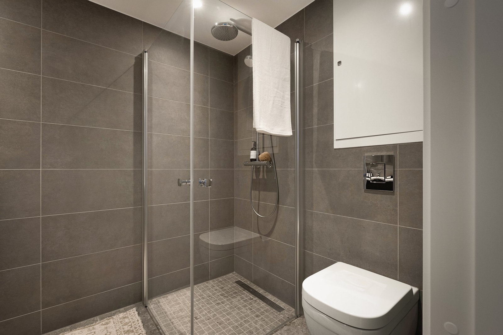 Dusjsone med innfellbare dører av glass. Dusjarmatur
tilkoblet hånddusj og regndusj. Galleribilde