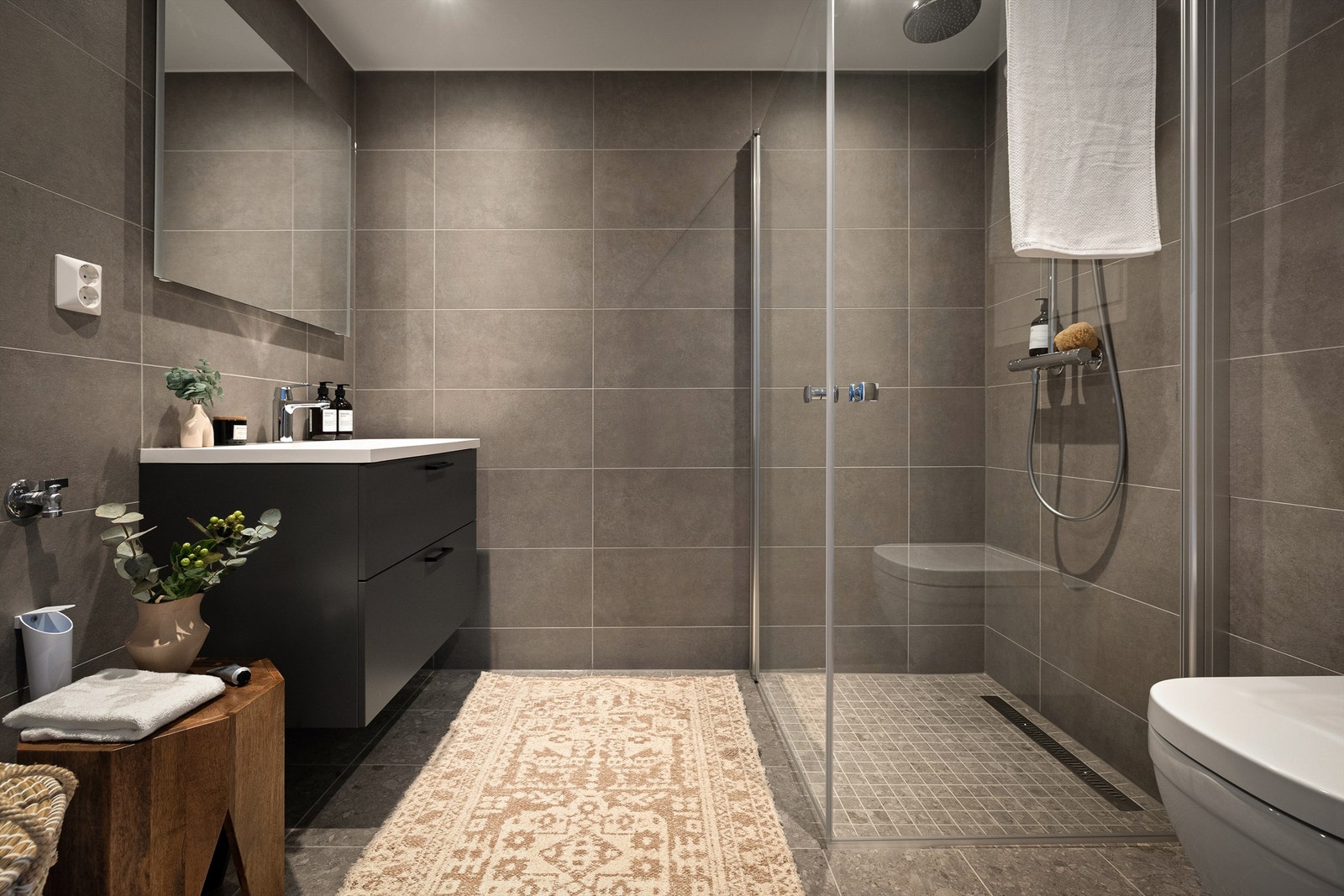 Stilfullt bad med flislagt gulv med vannbåren gulvvarme og flislagte vegger Galleribilde