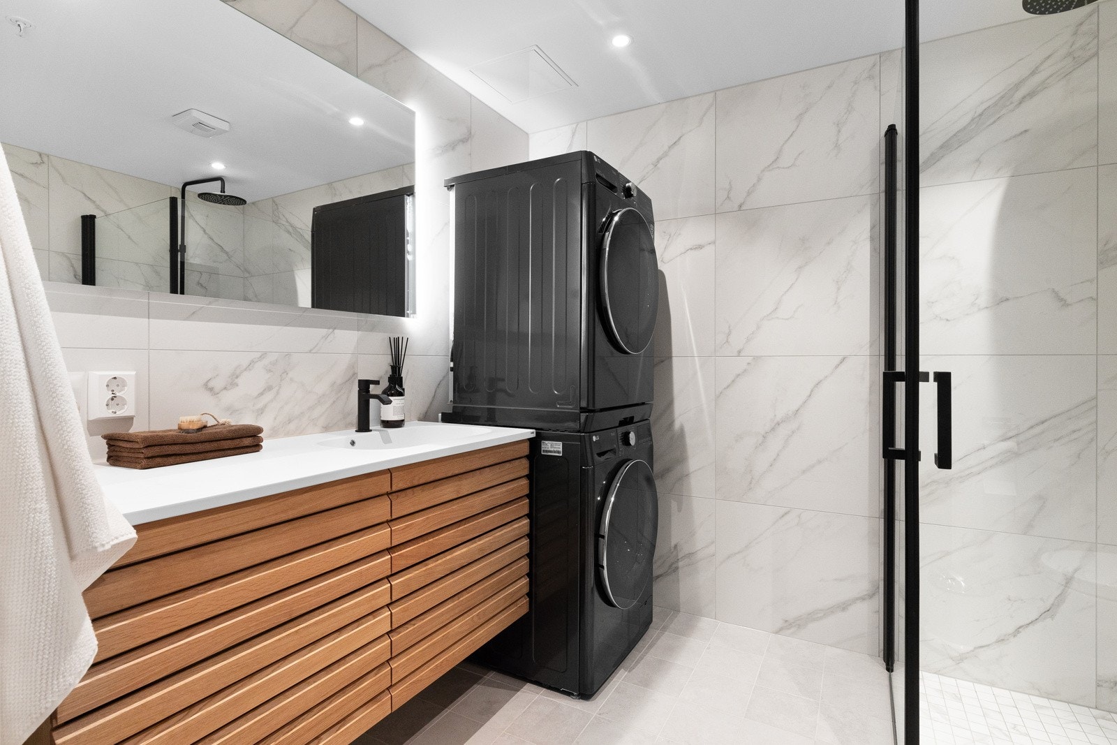 Baderommet har flotte marmorliknende fliser, downlights i himling, lekre sorte detaljer og flott innredning. Galleribilde