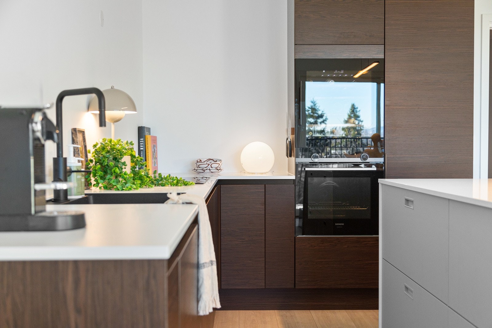 Kjøkkeninnredningen er utstyrt med flotte helintegrerte hvitevarer som oppvaskmaskin, stekeovn, indusksjonstopp, vinskap og kjøle-/fryseskap. Galleribilde