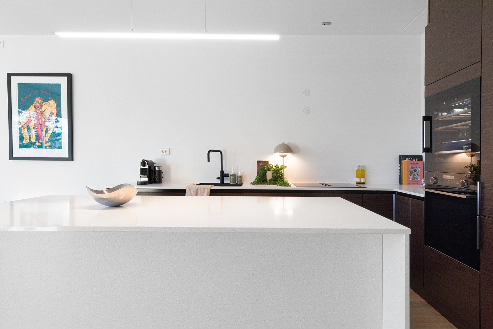 Den praktiske kjøkkenøyen gir godt med benkeplass og ekstra skapplass, samt fungerer som et naturlig skille mellom kjøkkensonen og spisestuen. Galleribilde