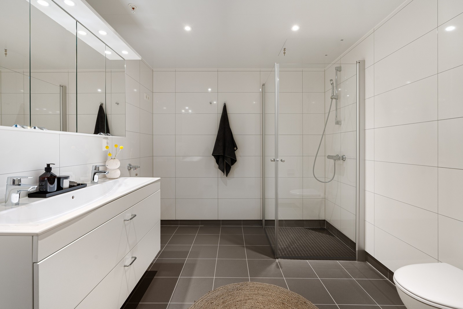 Flislagt bad, varmekabler i gulv og plassbesparende løsninger som dusj med innfellbare glassdører.