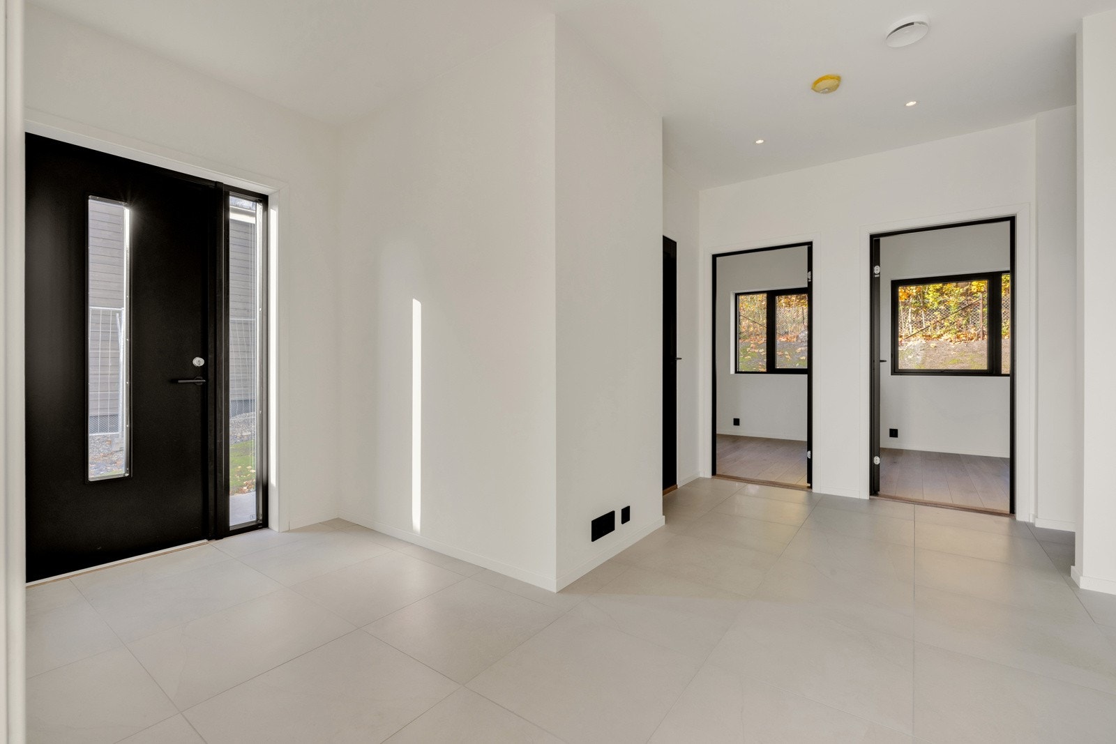 Hallen i første etasje er innbydende og lys med fliser på gulv og plass til garderobeløsning i egen nisje. Galleribilde