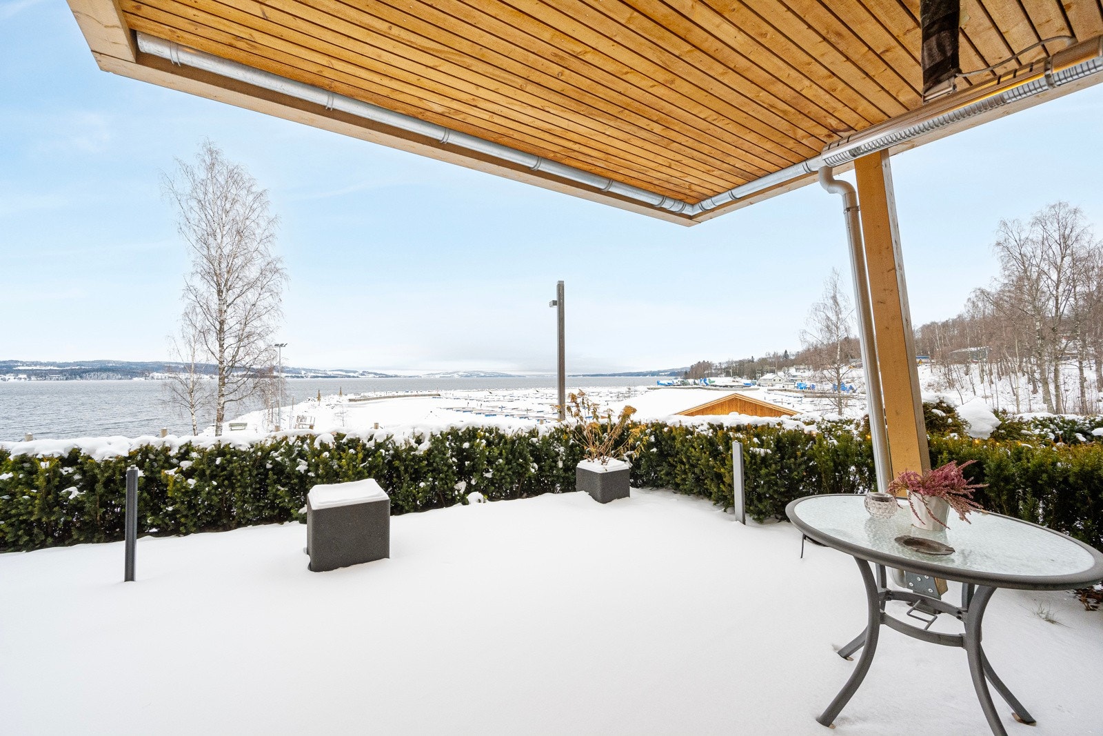 Leiligheten har en romslig, delvis overbygget terrasse med flott utsikt mot Mjøsa og båthavna i Rambekkvika Galleribilde