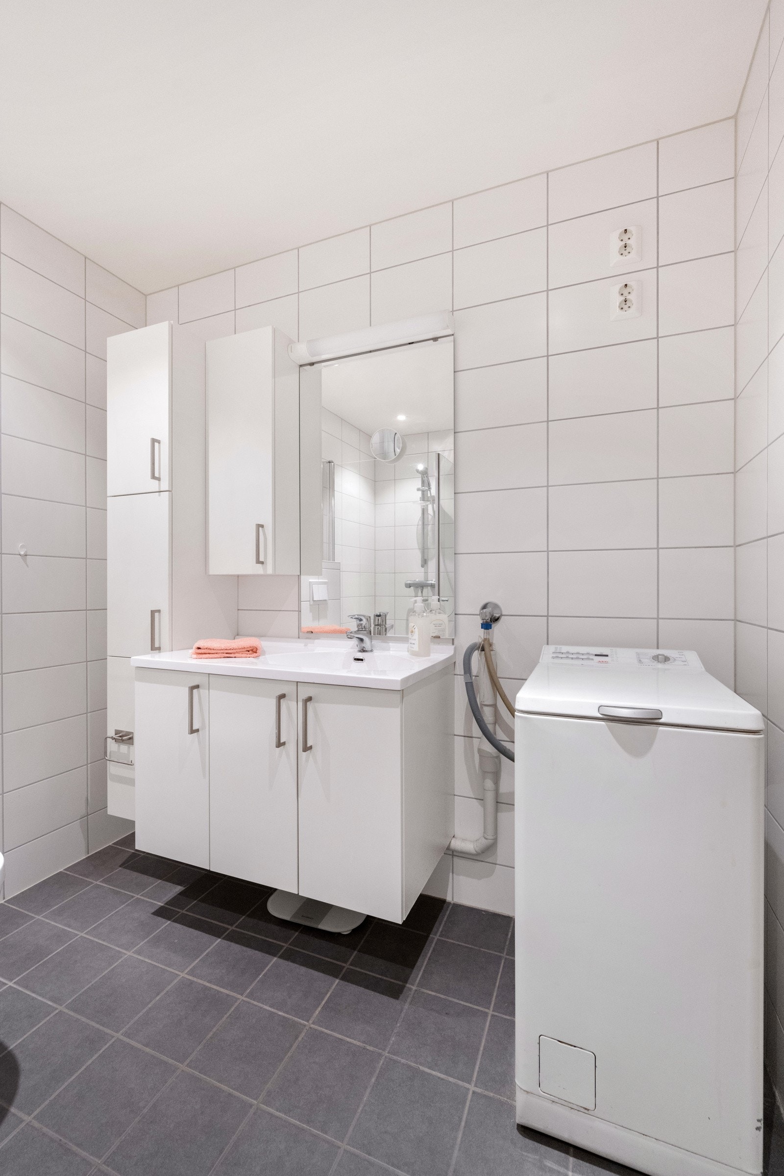 Badet har flislagt gulv med varme og fliser på vegger. Opplegg for vaskemaskin Galleribilde