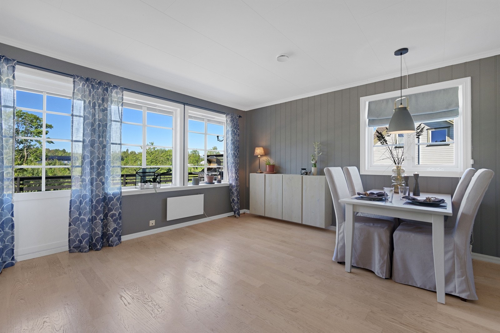 Stua har store vindusflater med fint kveldslys og utgang til en diger terrasse Galleribilde