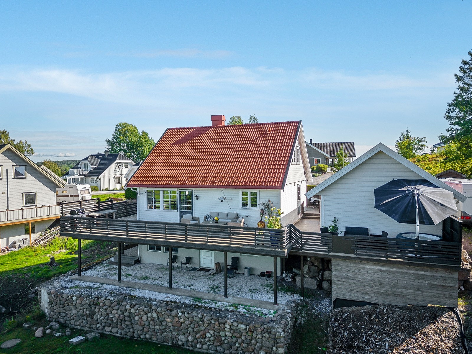 Fasade vest - vi ser den store terrassen og baksiden av garasjen Galleribilde