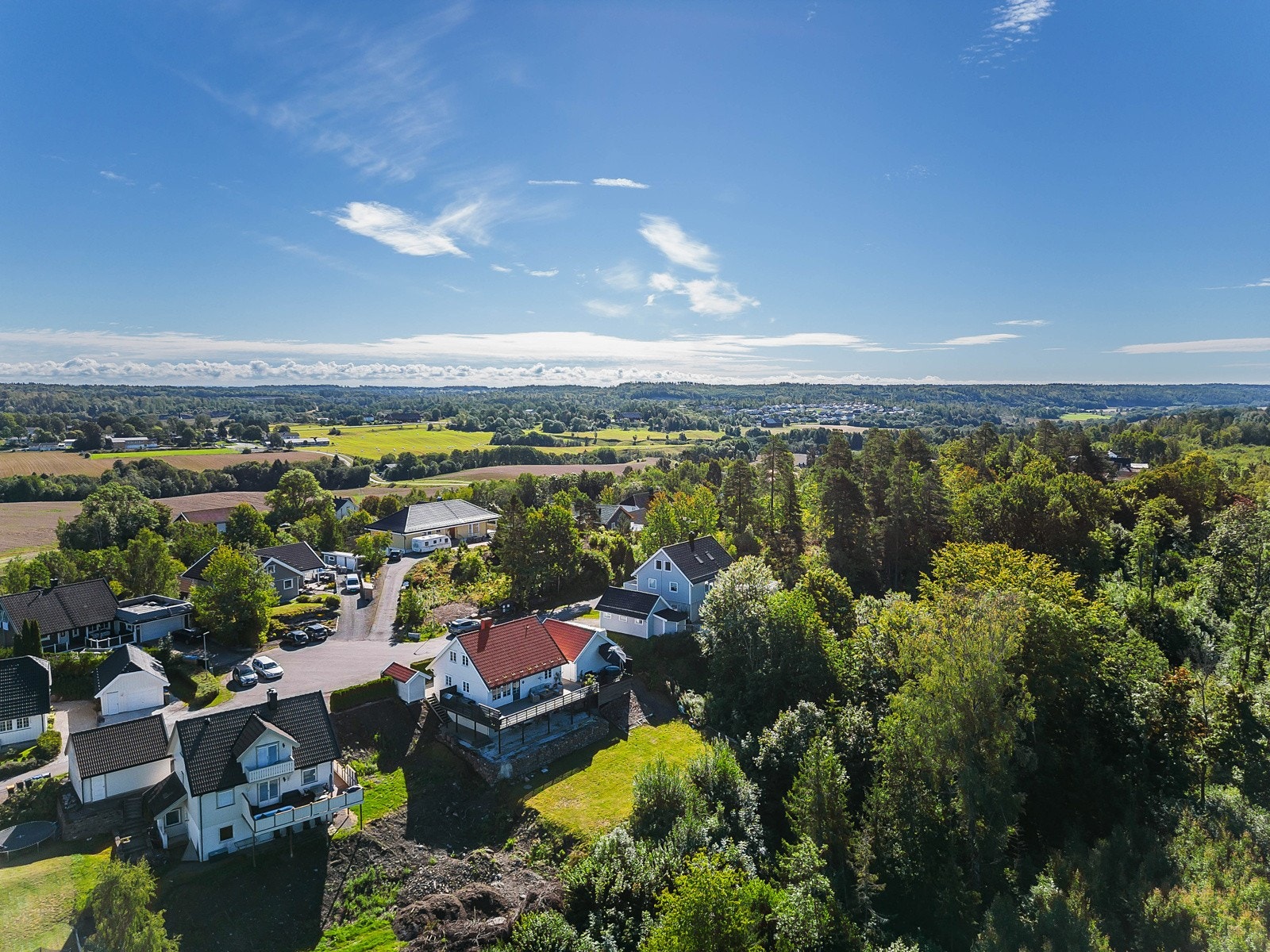 Her ser vi et dronebilde av huset og de landlige omgivelsene Galleribilde