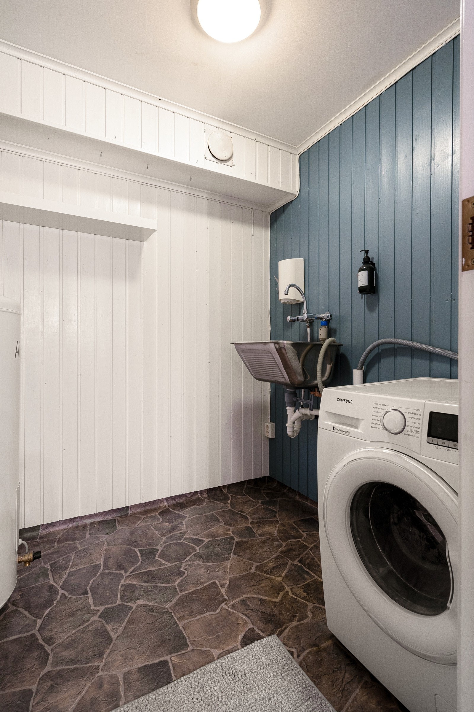Boligen har et praktisk vaskerom med servant og opplegg for vaskemaskin. Galleribilde