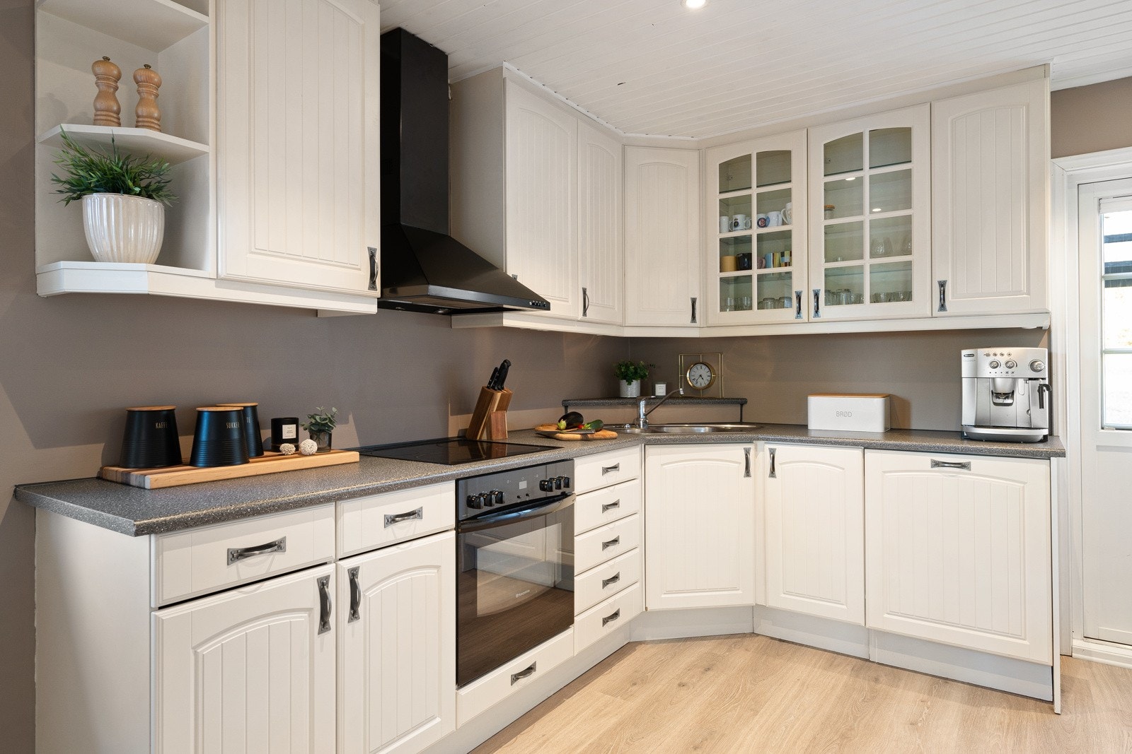 Kjøkken i klassiske farger med integrert stekeovn, platetopp og oppvaskmaskin. Galleribilde