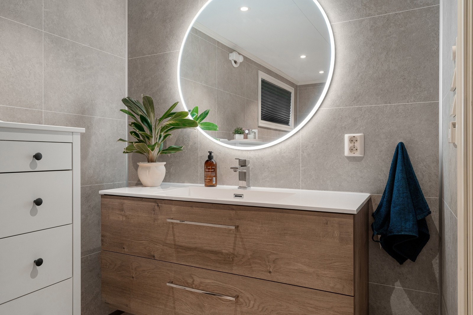 Badet er utstyrt med vegghengt servantinnredning bestående av skuffer og speil med overlys. Galleribilde