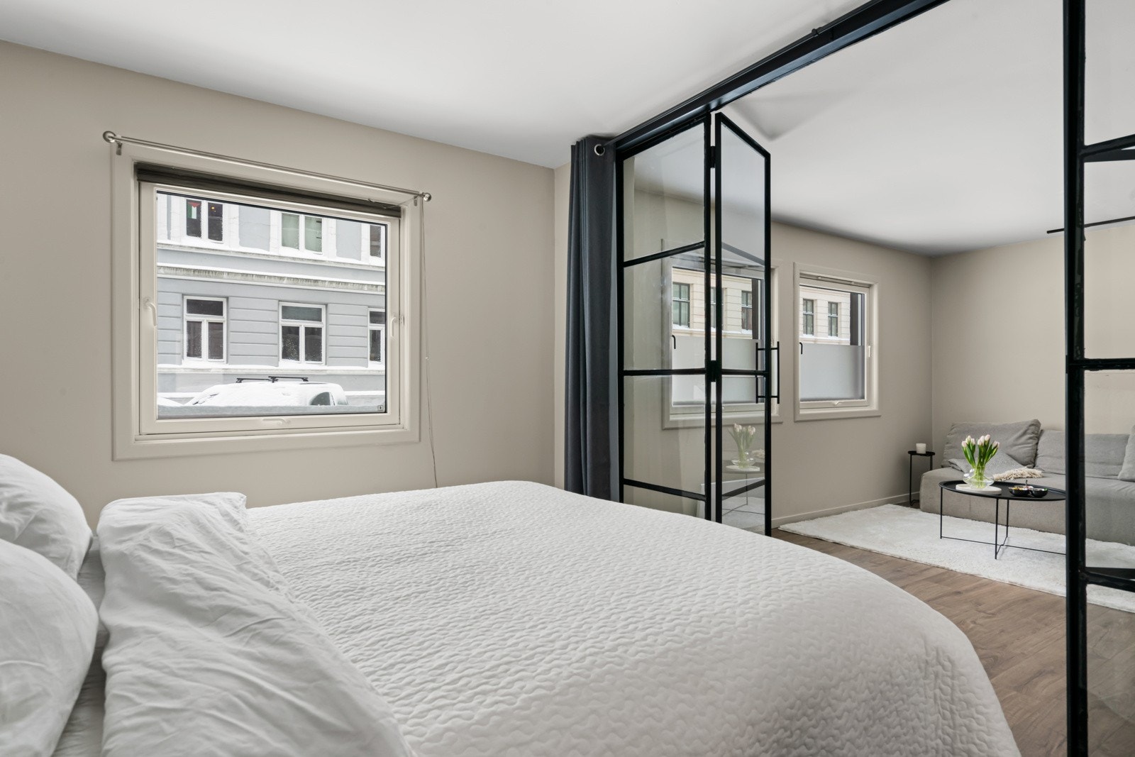 Veggene ble malt i en delikat og rolig fargepallett i 2024 som harmonerer fint med den sorte smijernsdøren. Galleribilde