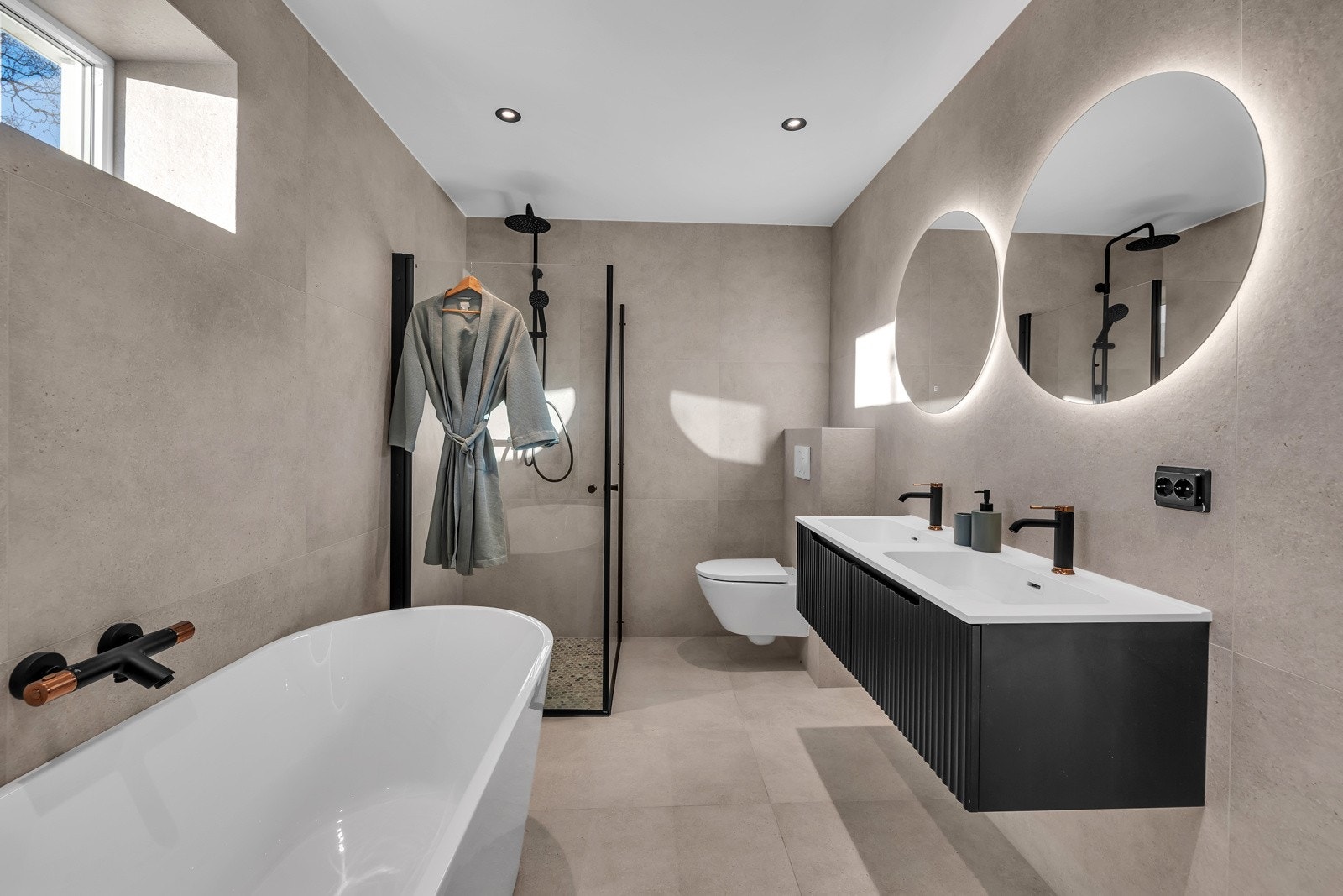 Innbydende bad med badekar, dusj og dobbelvask Galleribilde