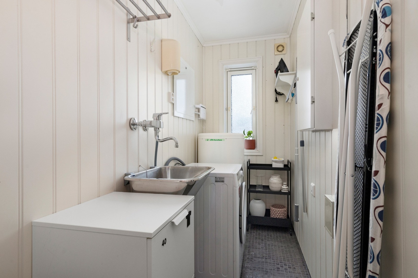 Eget flislagt vaskerom med opplegg for vaskemaskin og skyllekum. Galleribilde