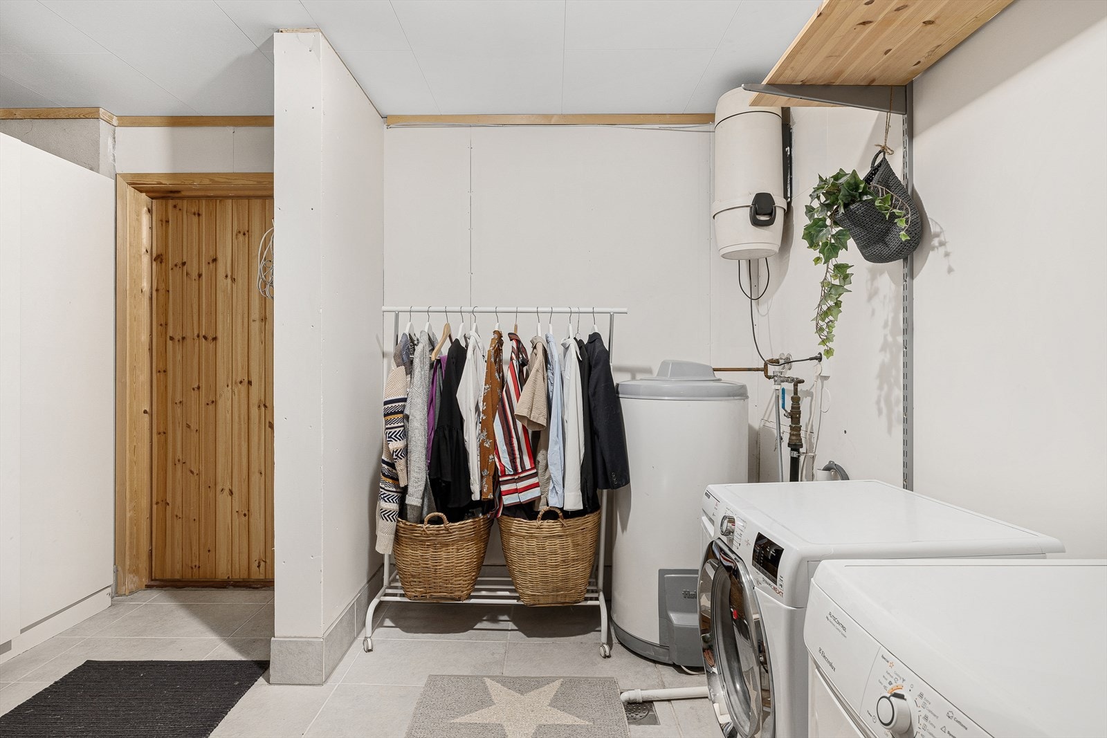 Vaskerom med flis på gulv og vegger med oppkant flis, malte gipsplater og pusset mur. Tak i takessplater. Innredet med hyller, opplegg til vaskemaskin og garderobeskaper. Galleribilde