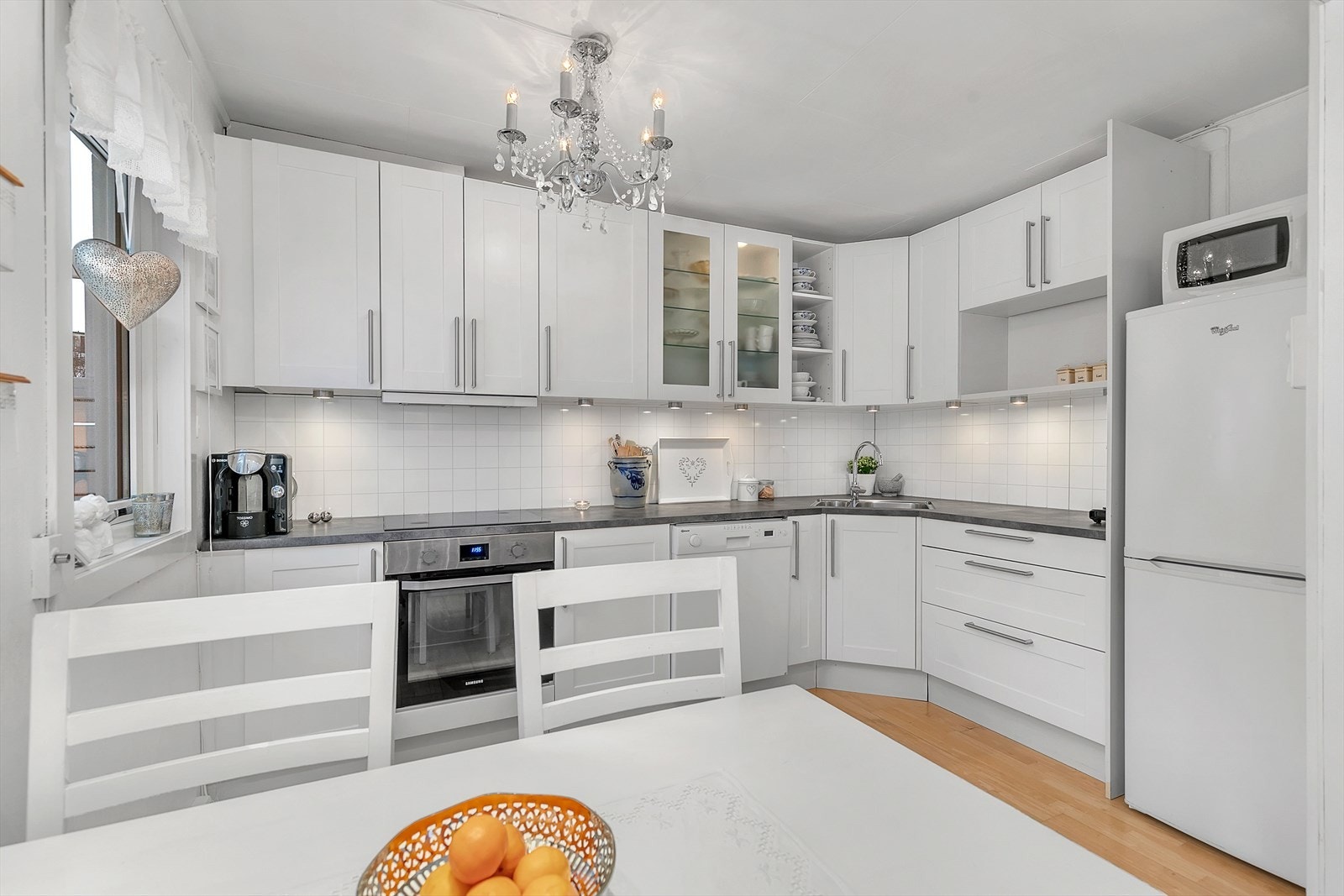 Kjøkkenet har lys innredning med profilerte fronter Galleribilde