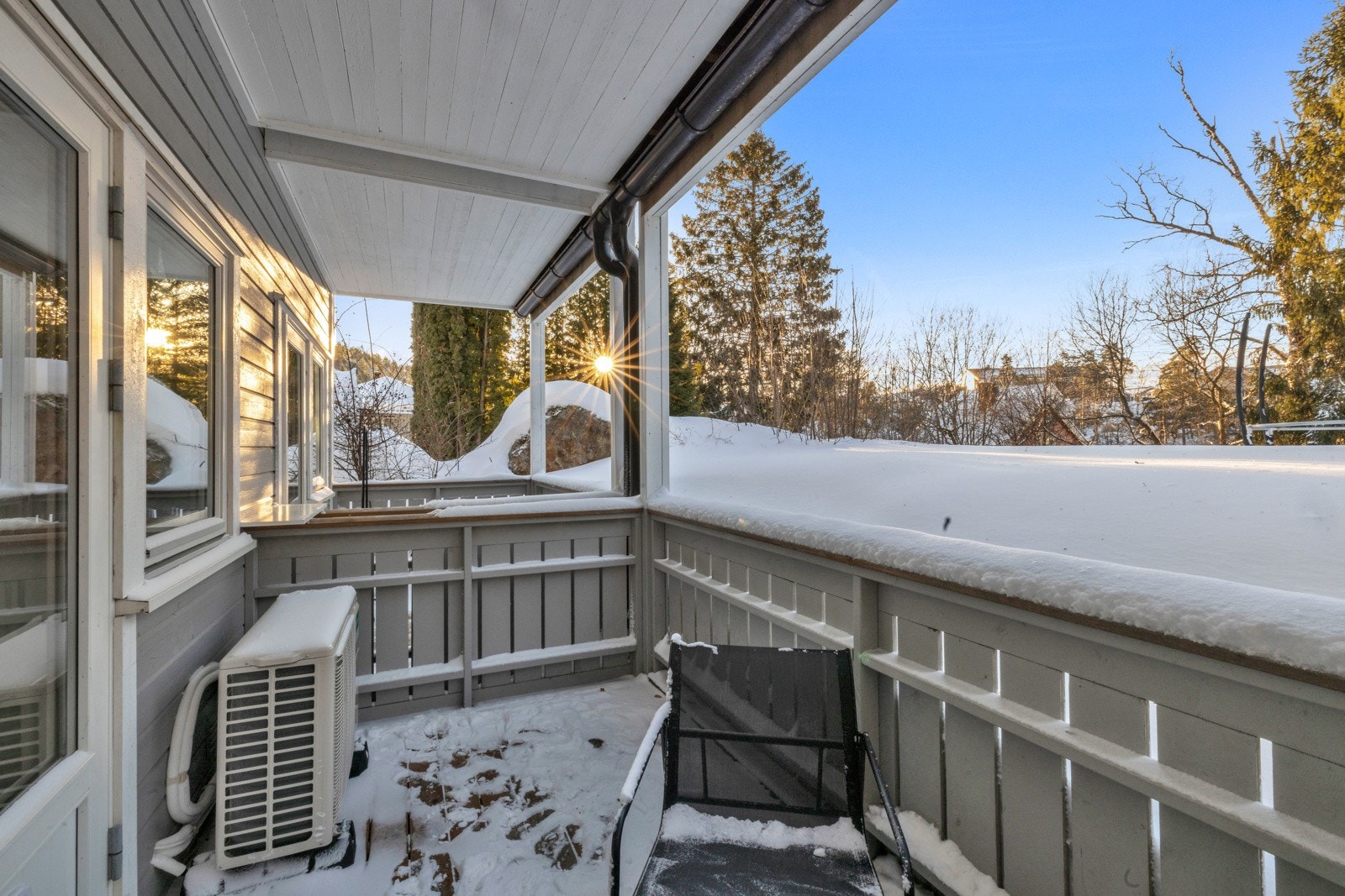 Terrassen har spaltegulv av tre og et rekkverk med stående panel rundt Galleribilde