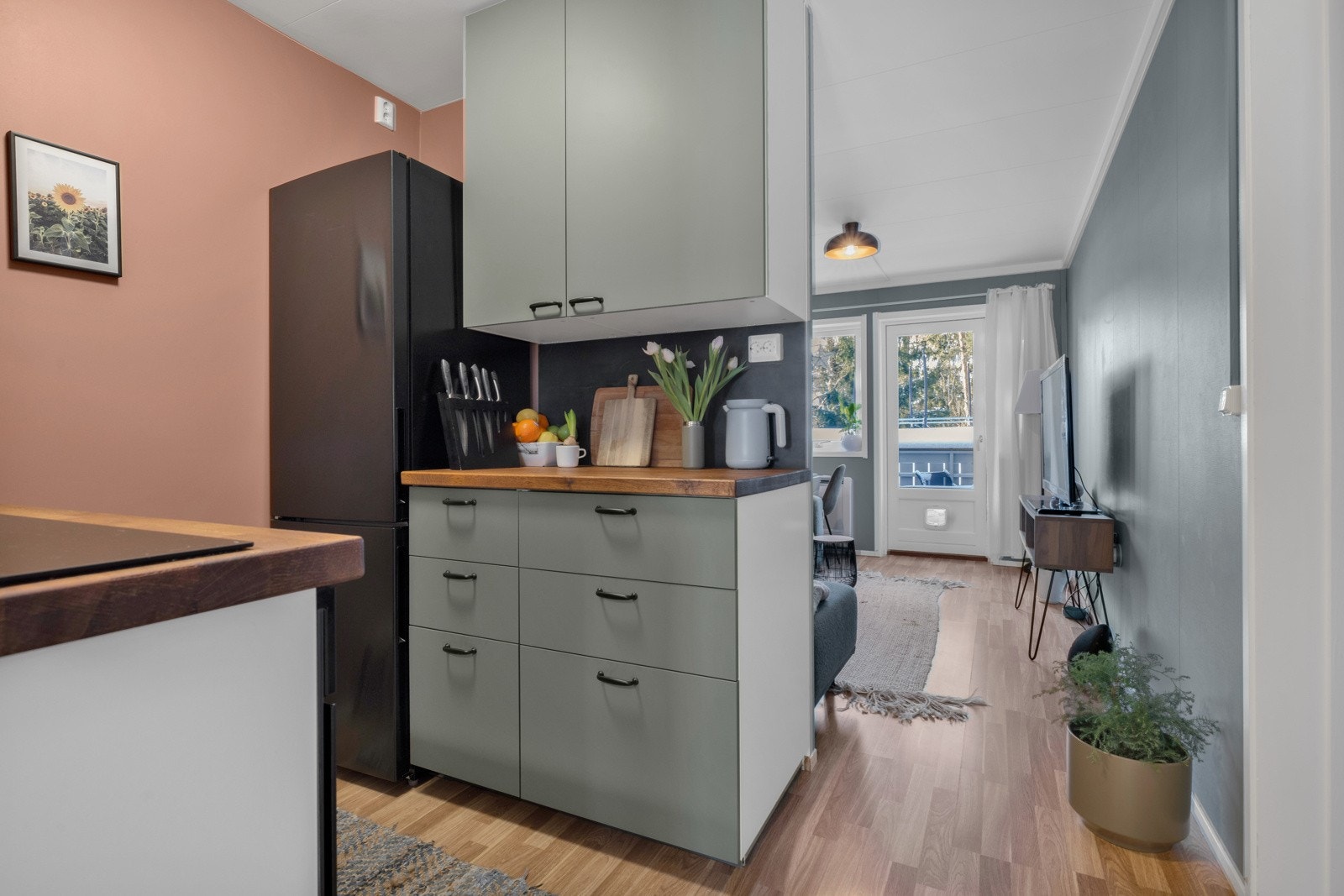 På veggene over benken er det flisplater som matcher håndtakene og innerst er det avsatt plass til kjøleskap Galleribilde