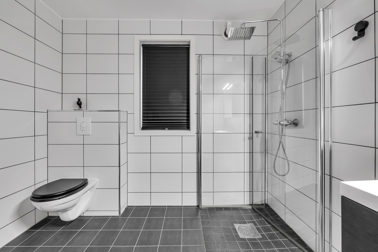 Praktisk innredning med lagring i kolonialskuffer, innfellbare dusjdører, vegghengt toalett, opplegg for vaskemaskin og tørketrommel m.m. Galleribilde