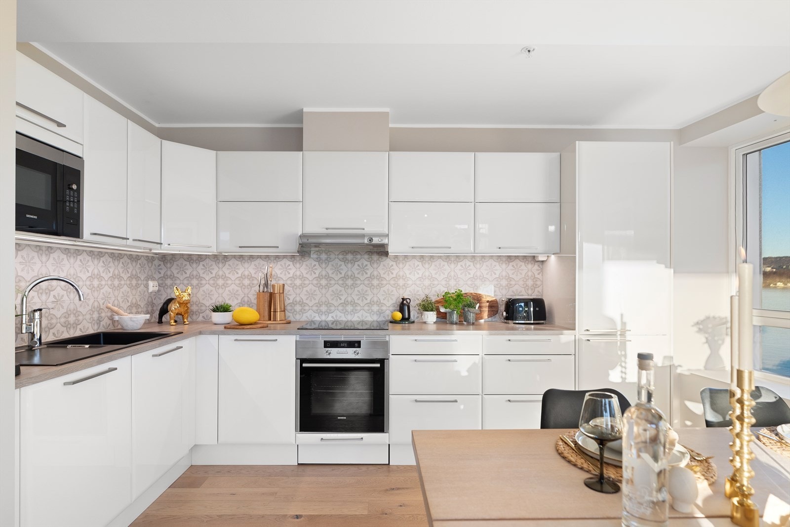 Kjøkkenet er av lyse slette fronter, laminat benkeplate, oppvaskkum og ventilator Galleribilde