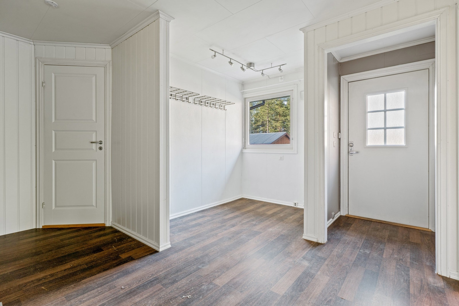 Her kommer man inn et vindfang med gråmalte vegger og laminat på gulvet. Galleribilde