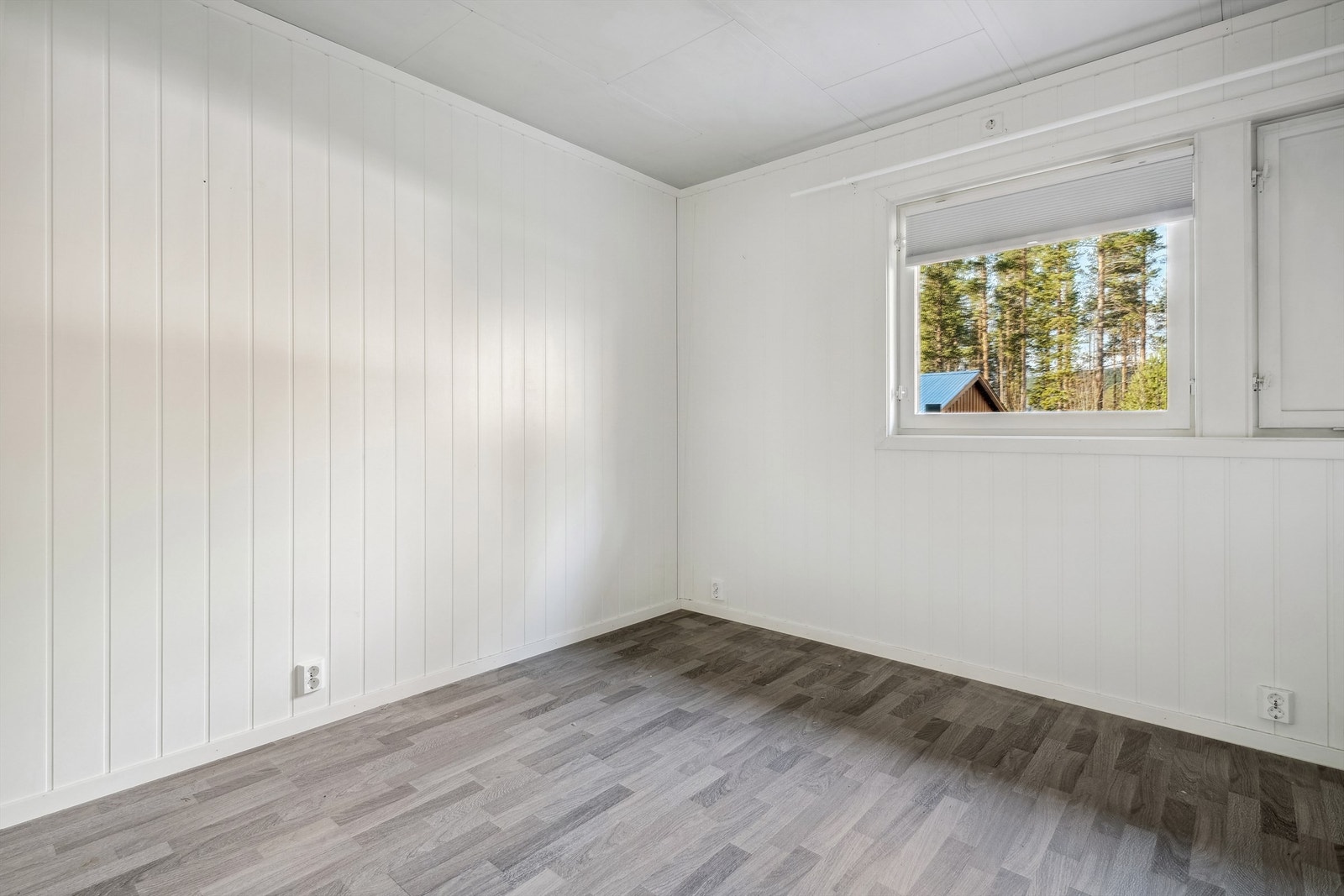 Det er fire soverom i boligen, tre i 1. etasje og ett i 2. etasje. Ett soverom har hvitmalte panelplater på veggene og laminat på gulvet. Galleribilde