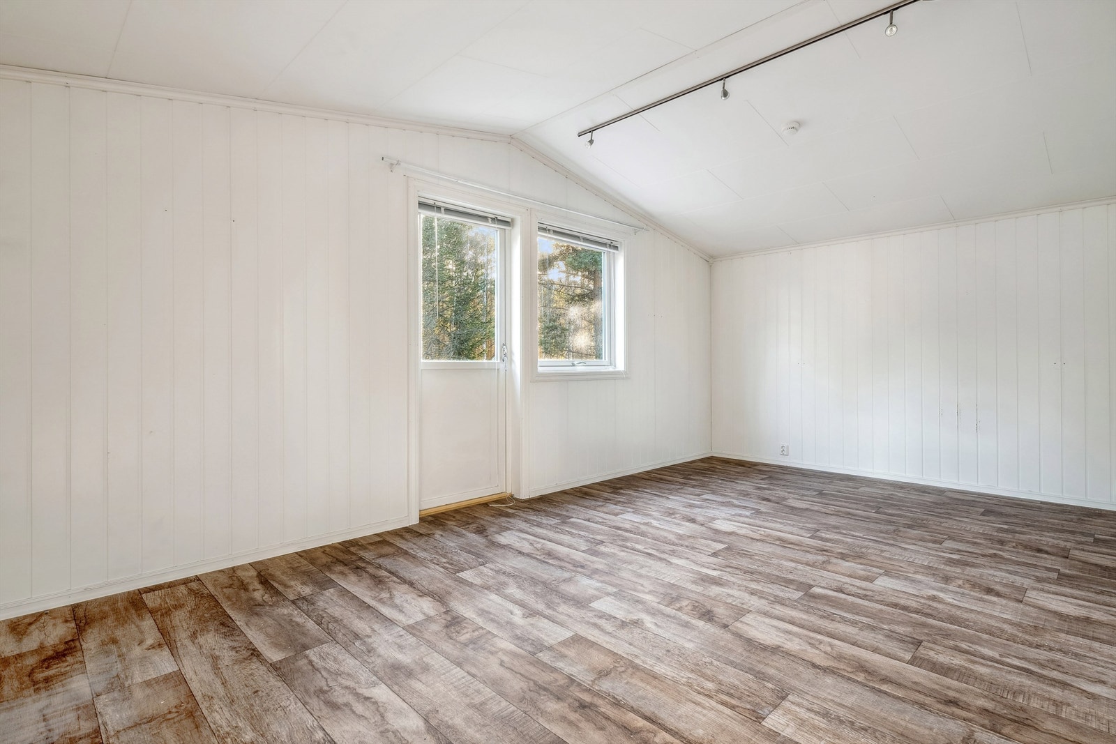 Soverommet i 2. etasje har brun laminat på gulvet og lysmalte panelplater på veggene. Dette rommet har adkomst ut til egen balkong. Dette er det største soverommet i boligen. Galleribilde