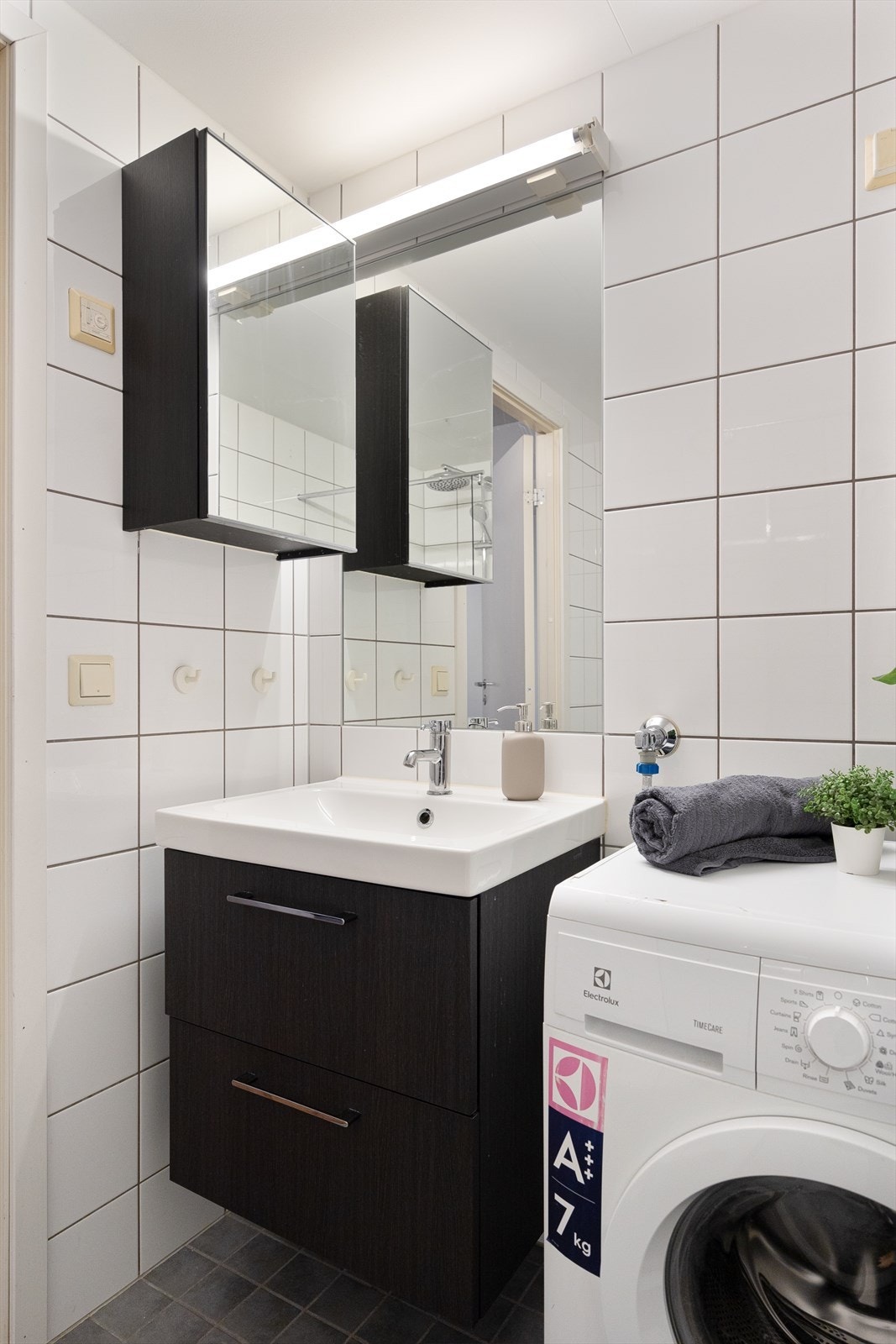 Badet er innredet med vegghengt klosett, servant nedfelt i innredning og speil. Galleribilde