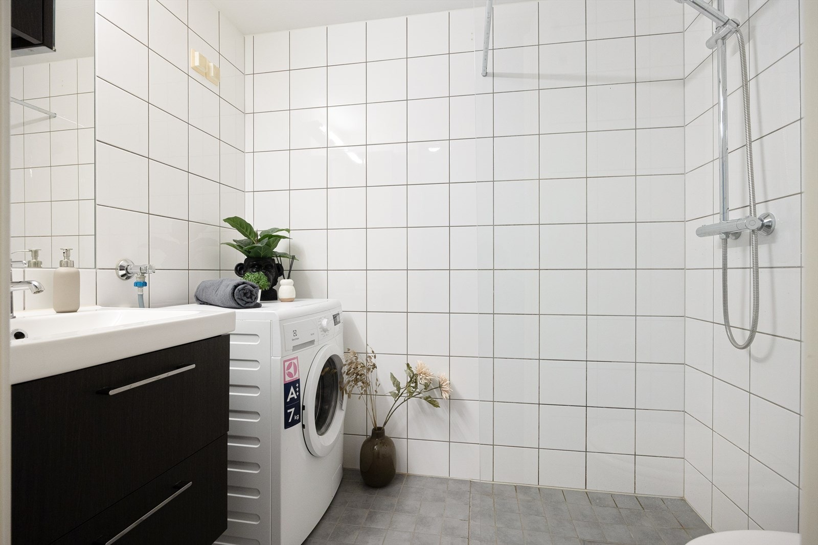 Pent flislagt baderom med elektrisk gulvvarme og opplegg for vaskemaskin. Galleribilde