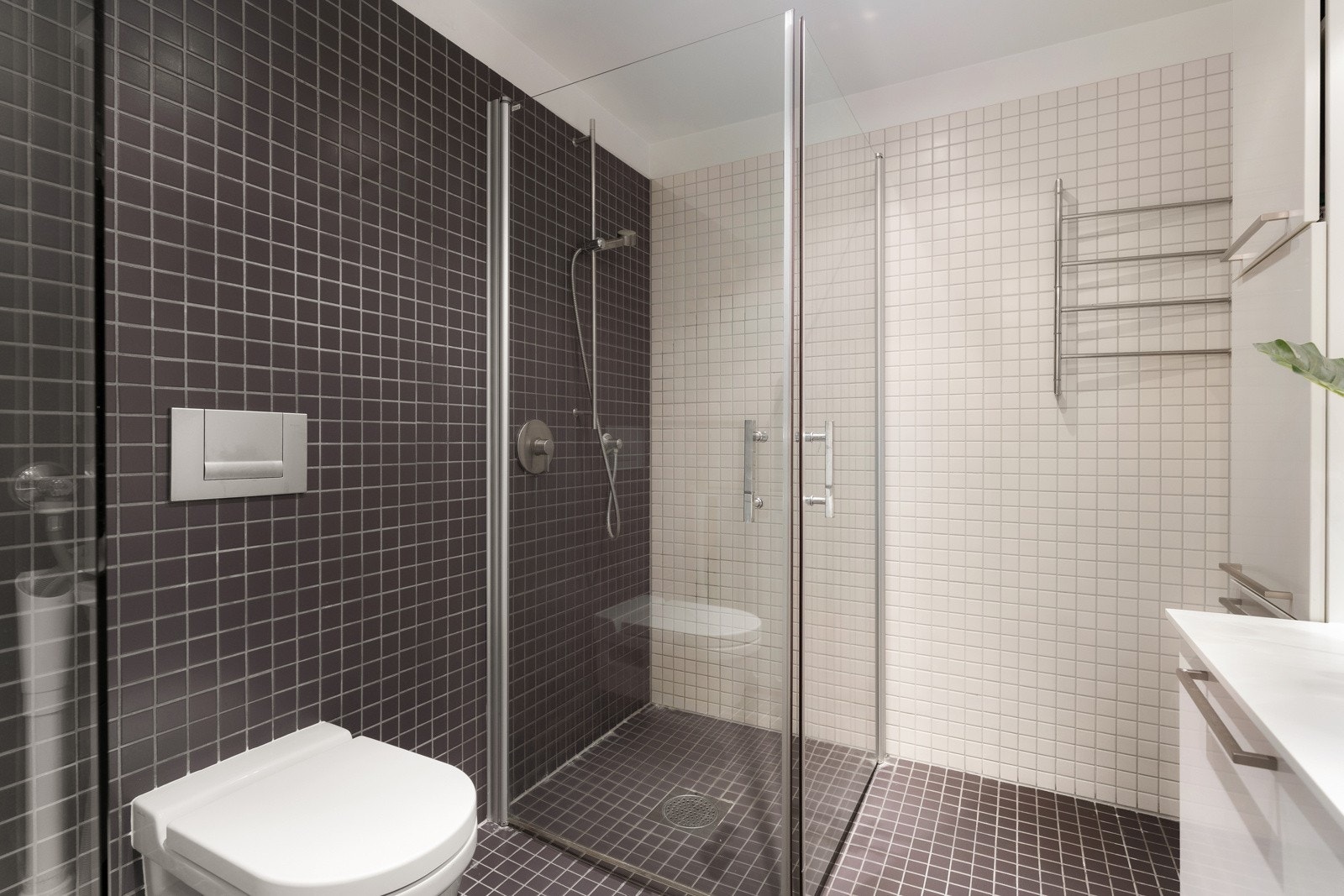 Utstyrt med romslig dusjsone og veggmontert klossett - Glassvegg i frostet glass mot stue. Galleribilde