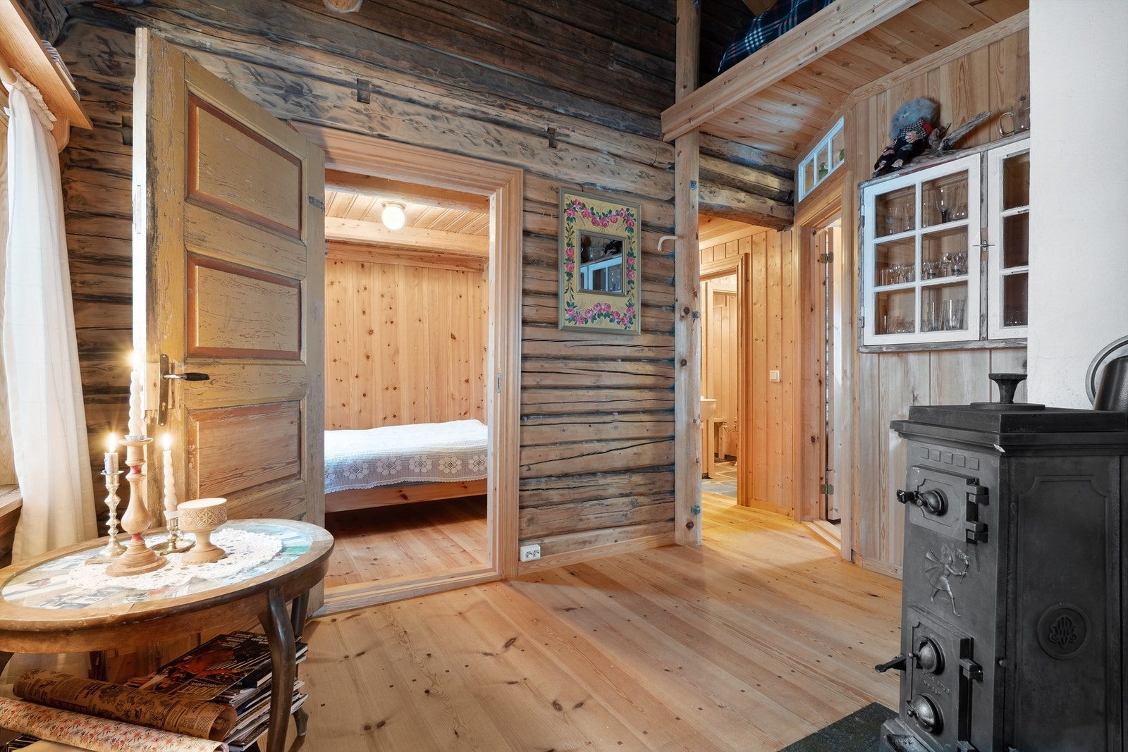 Soveromsgangen/mellomgangen har laftede vegger og tregulv. Her er det en vedovn som gir godt med varme. Galleribilde
