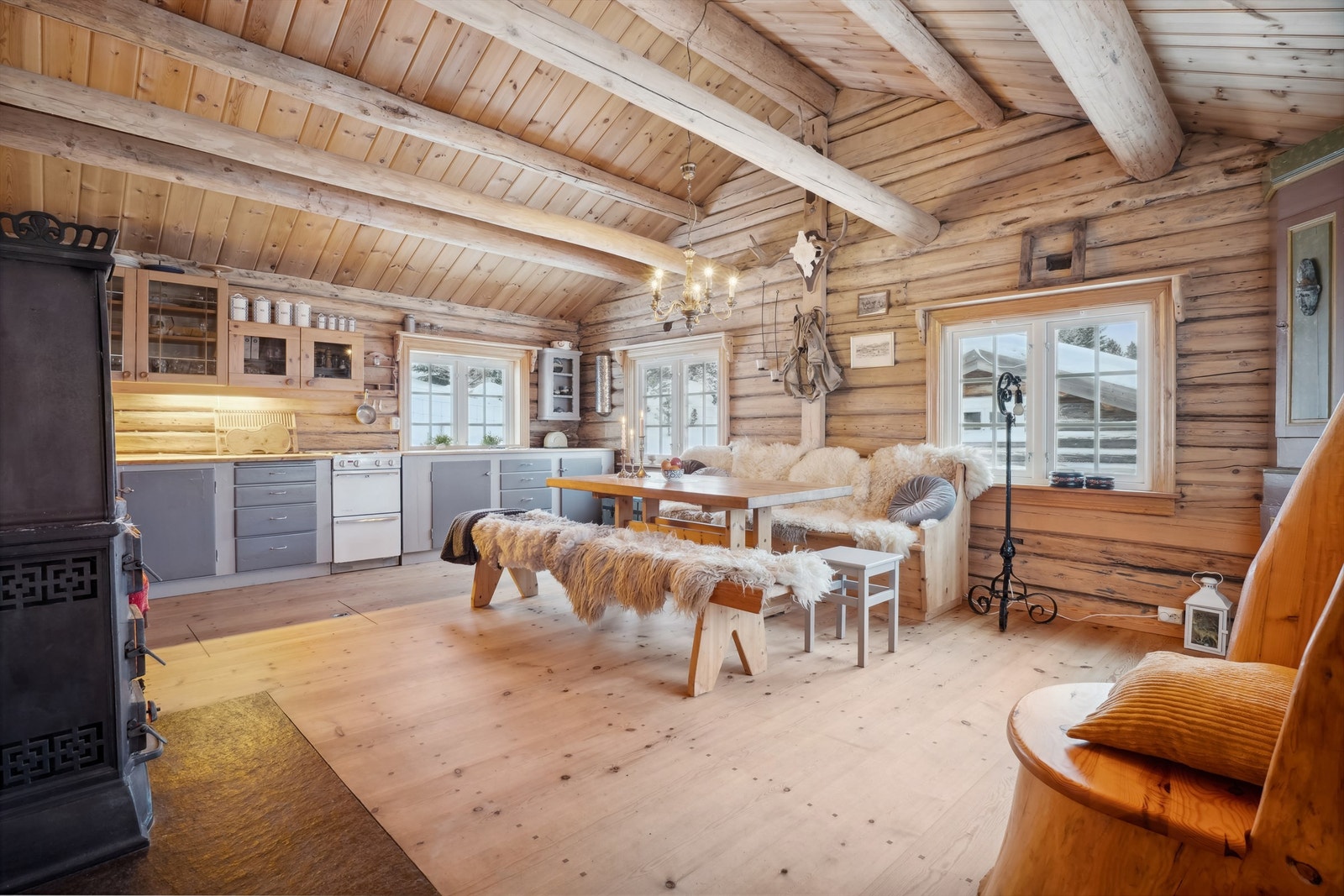 Eldre plassbygd kjøkkeninnredning med malte fronter og heltre benkeplate. Innredningen består av 2 stk overskap med glassdører og skap og skuffer i underdelen. Galleribilde